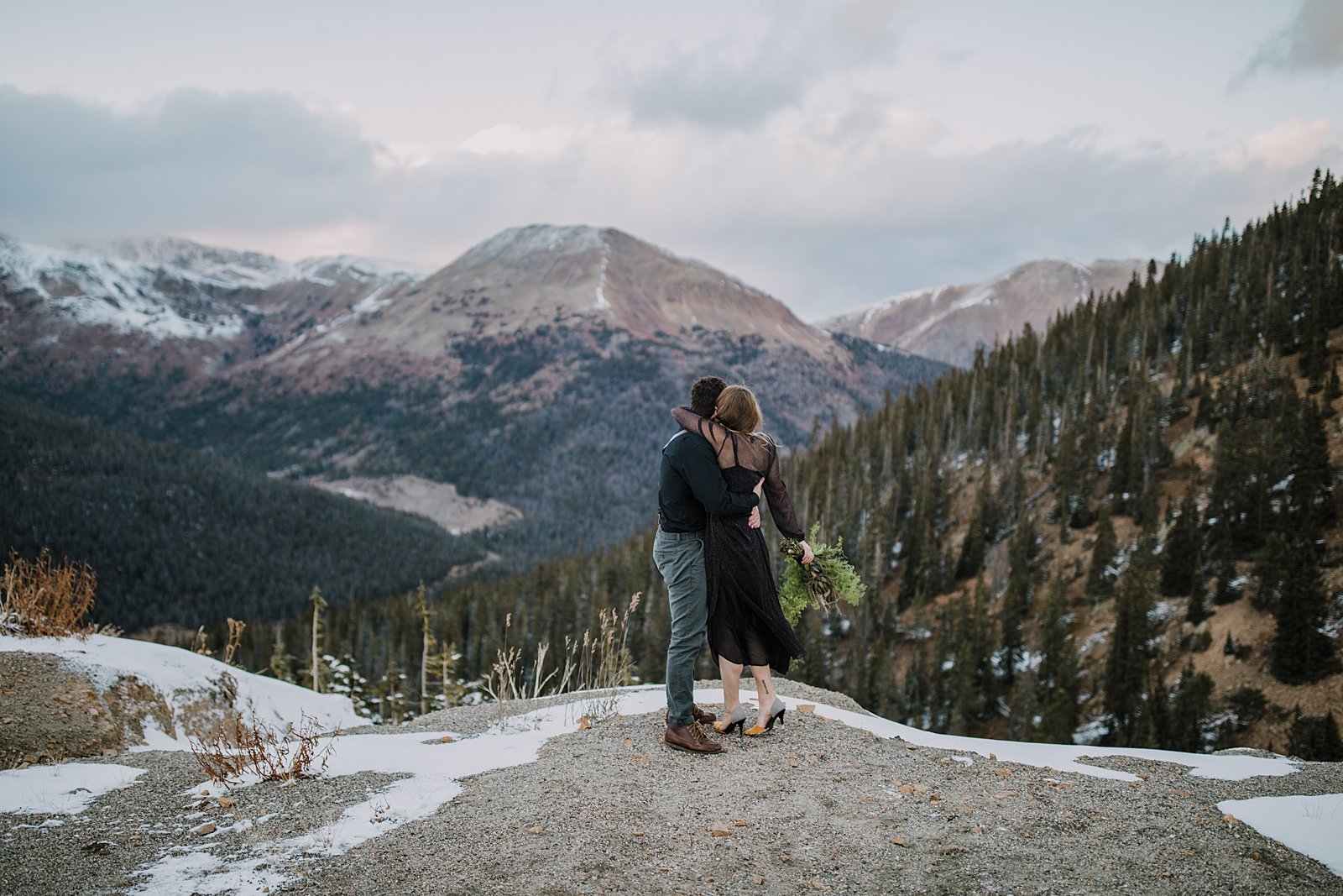 bride and groom watching the sunset together, snow capped mountain elopement, mountain pass elopement, summit county fall elopement, high alpine elopement, moody weather elopement
