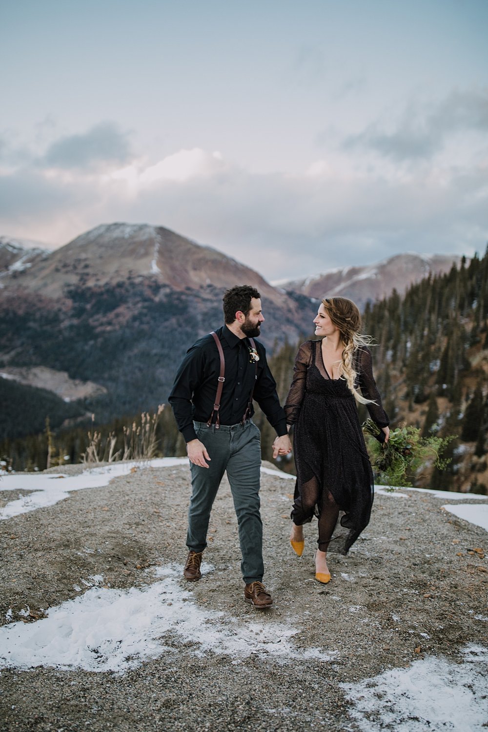 bride and groom holding hands in front of mountain backdrop, arapaho basin elopement, arapaho basin wedding, loveland pass wedding, loveland pass elopement, fall mountain elopement