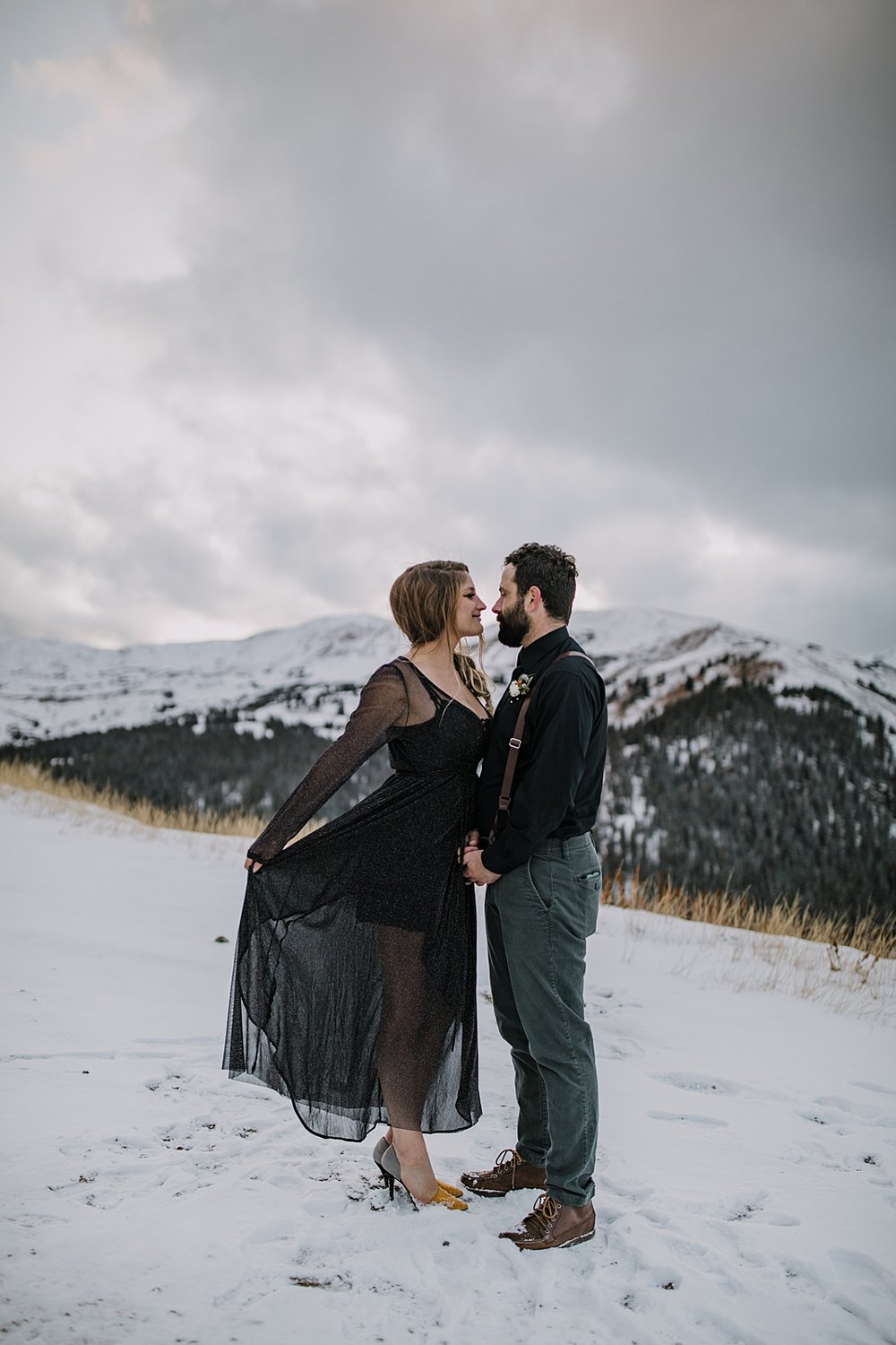 bride tossing wedding dress in the wind, snowy fall mountain elopement, stormy mountain elopement, celestial inspired mountain pass elopement, loveland pass sunset elopement, summit vow ceremony