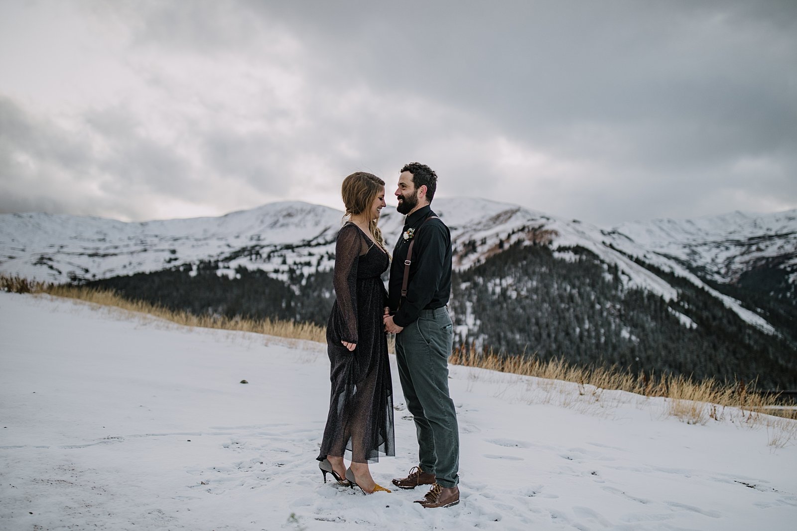 bride and groom laughing together, snowy fall mountain elopement, snow covered peaks on loveland pass, mountain top elopement, mountain top ceremony, mountain peak ceremony, summit vow ceremony