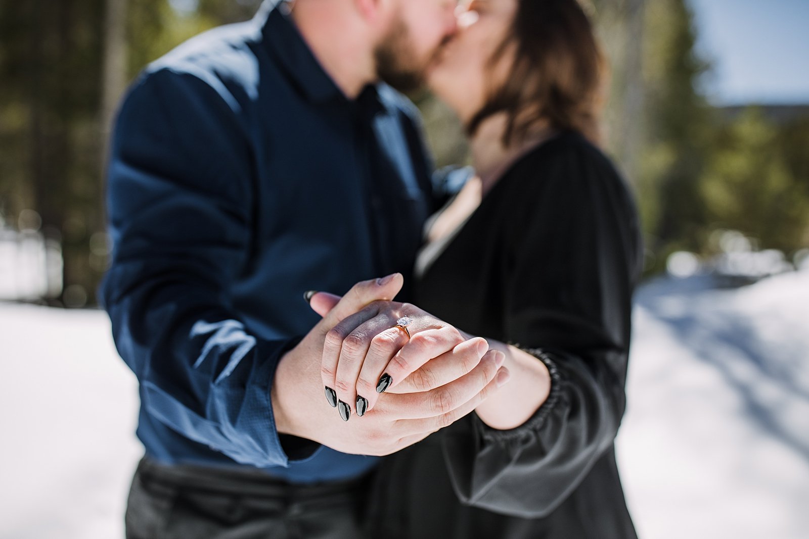 couple kissing and showing off engagement ring, black engagement nails, black proposal nails, engagement ring posing, georgia pass engagements, georgia pass proposal, snowmobile proposal