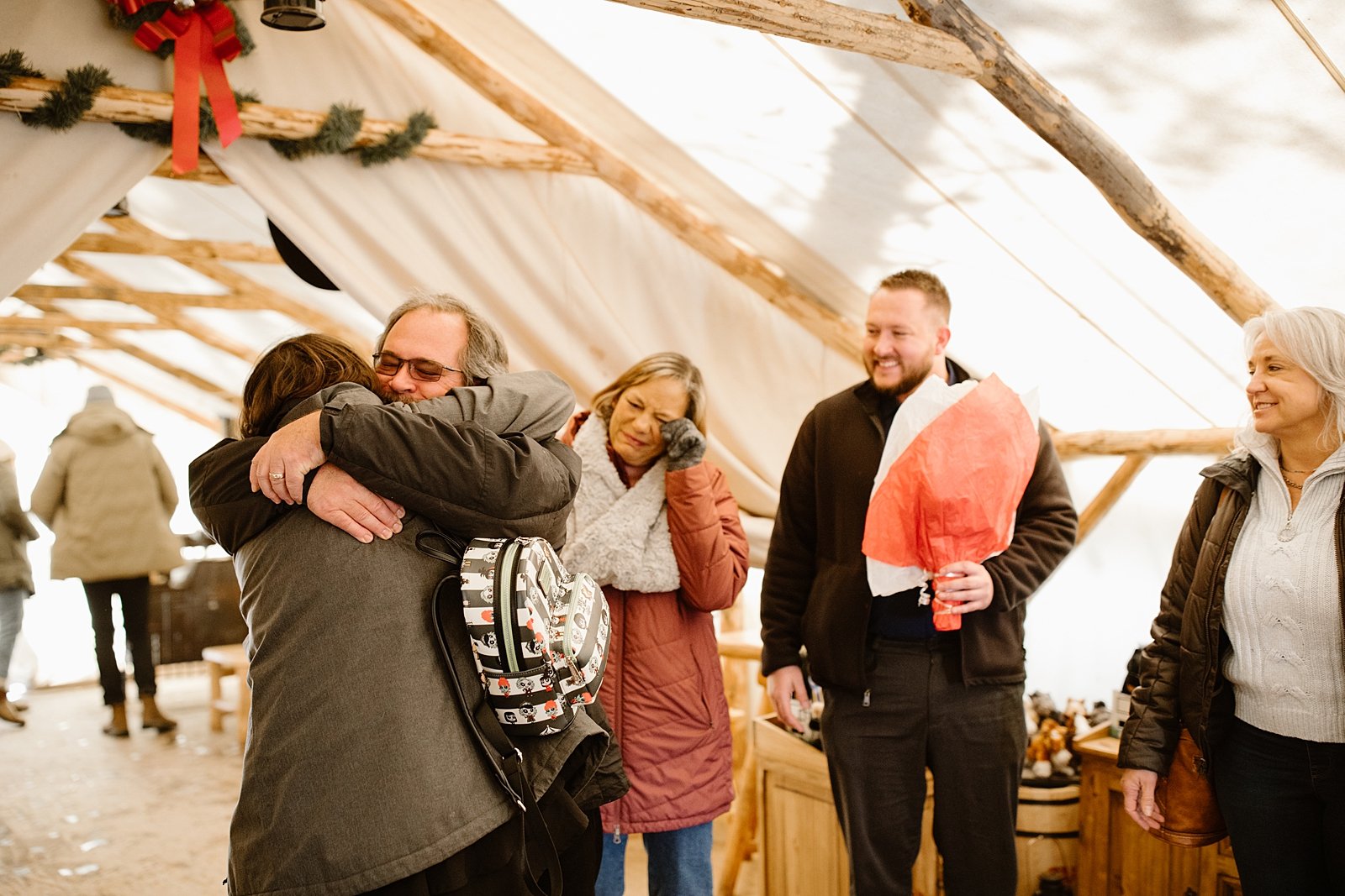family celebrating couples proposal, proposal celebration,  canvas tent engagement, canvas snow tent, winter canvas tent, wintery engagement celebration, canvas tent with wood burning stove