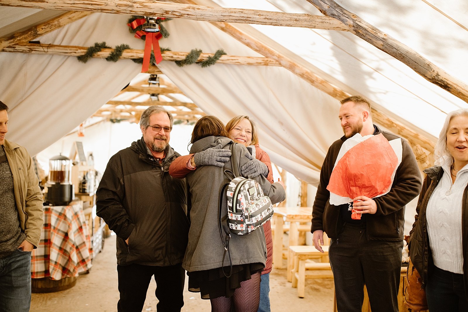 family celebrating couples proposal, proposal celebration,  canvas tent engagement, canvas snow tent, winter canvas tent, wintery engagement celebration, canvas tent with wood burning stove