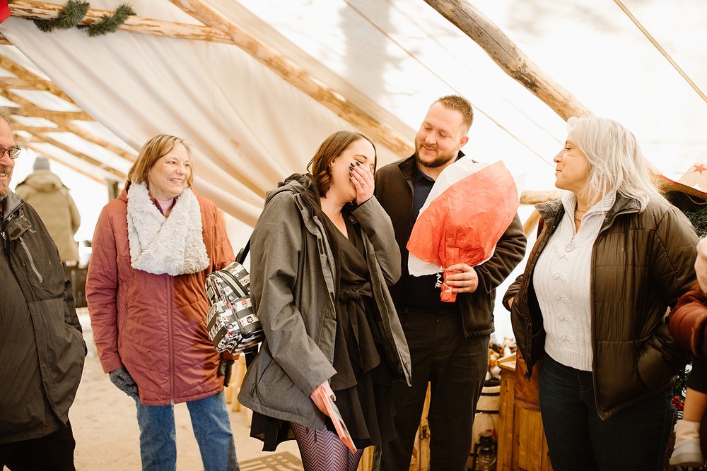 family celebrating couples proposal, proposal celebration,  canvas tent engagement, canvas snow tent, winter canvas tent, wintery engagement celebration, canvas tent with wood burning stove