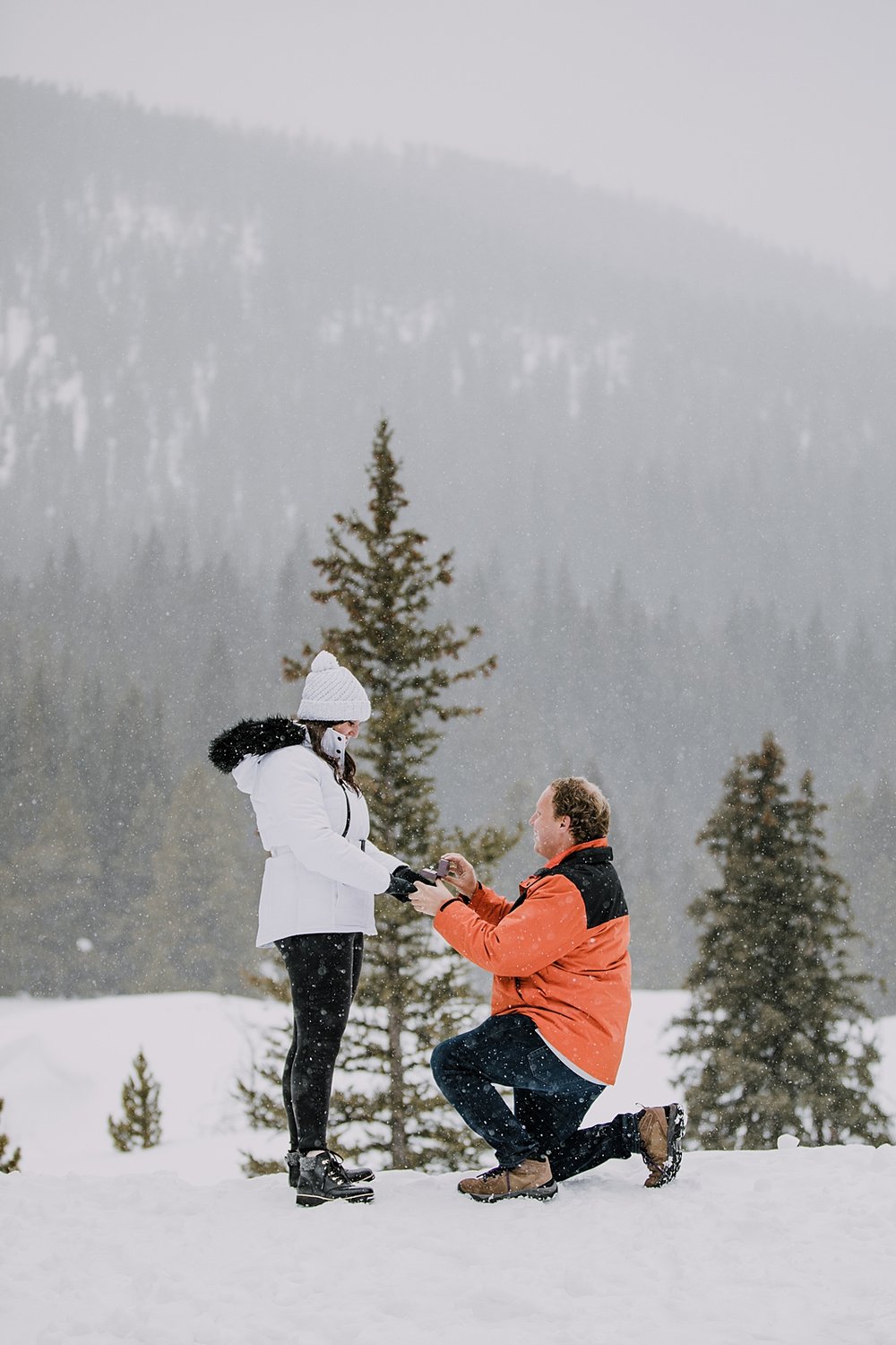 man kneeling to propose in the snow, man proposing in the snow, mountain proposal, colorado mountain proposal, winter proposal, backcountry proposal, white river national forest proposal