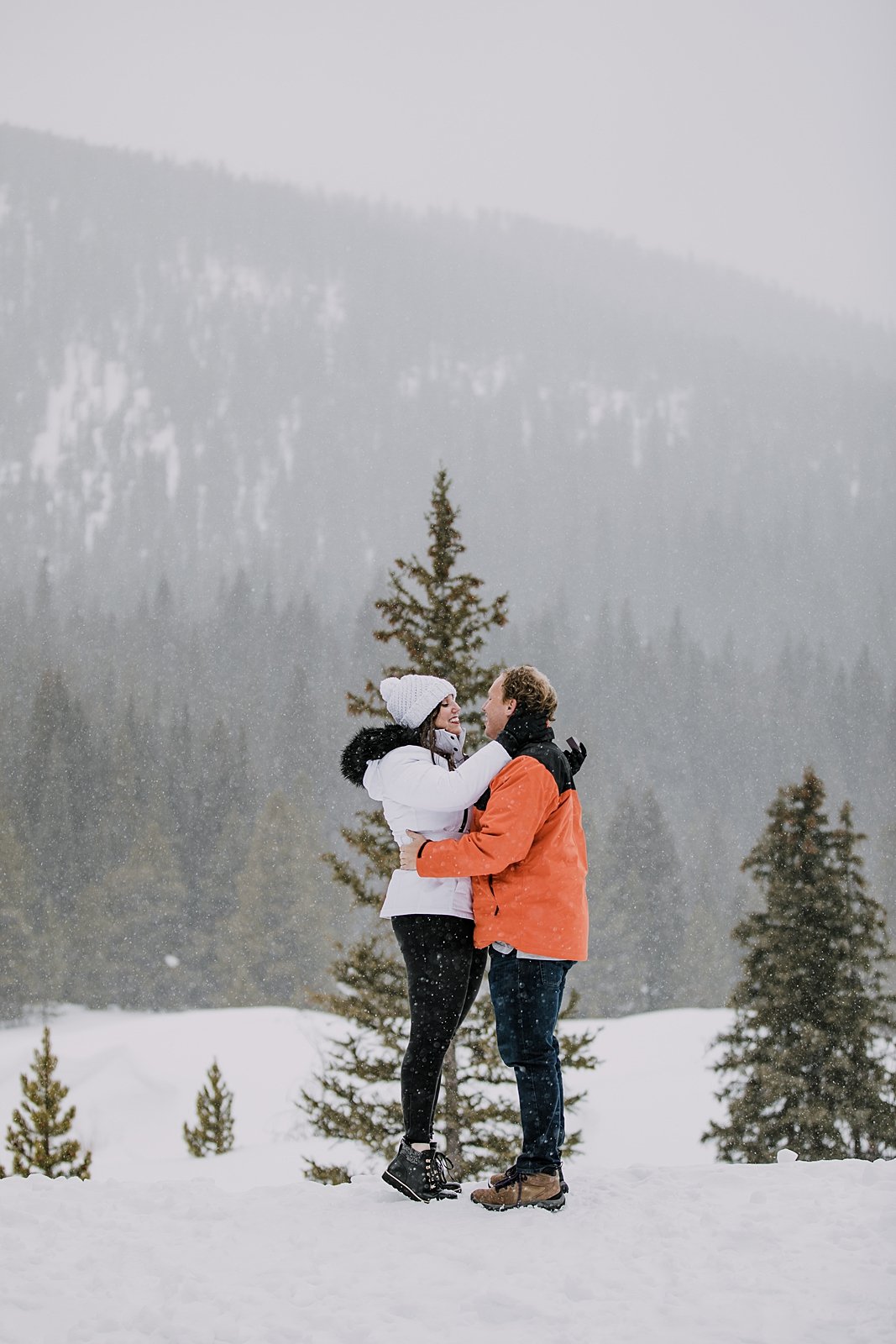 couple looking at one another, snowshoe proposal, snowy mountain proposal, breckenridge proposal, swan river valley winter activities, sleigh ride proposal, good times adventures sleigh ride
