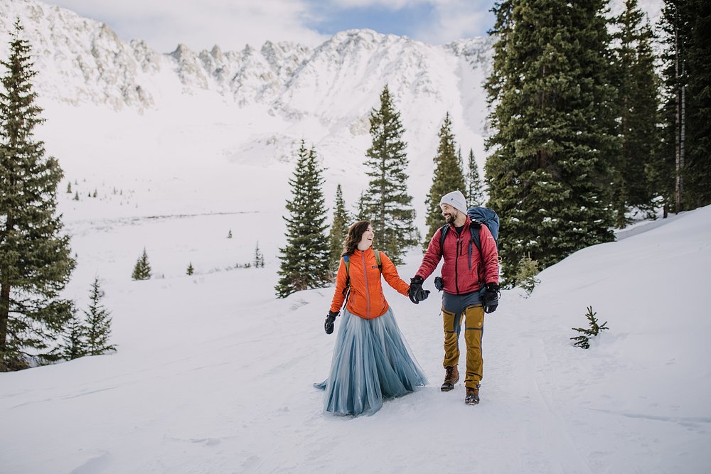 bride and groom hiking in the snow, mayflower gulch winter elopement, mayflower gulch elopement, leadville colorado elopement, leadville colorado winter elopement, snowy mountain wedding