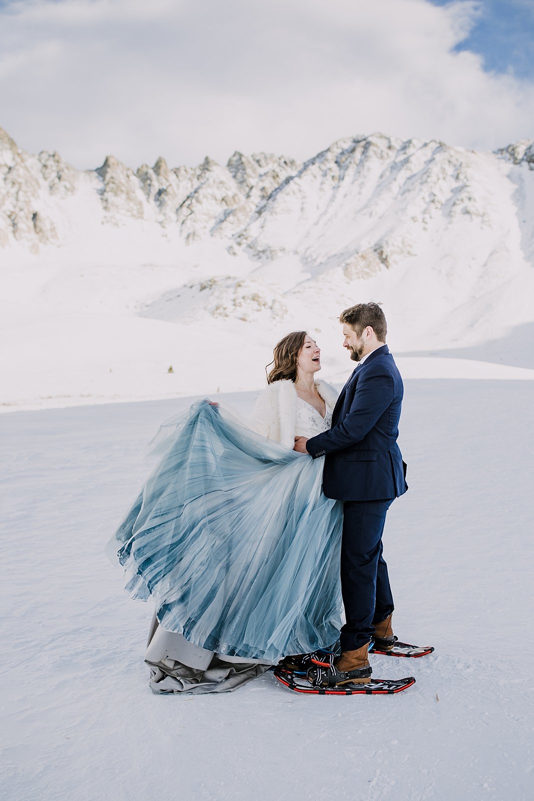 Bride and groom first dance in the snow, winter mountain elopement, yukon charlies womens snowshoes, colorado cabin wedding, bride swishing skirt, groom spinning bride