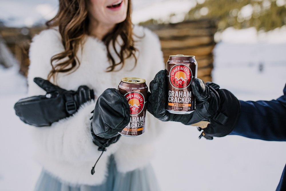 bride and groom cracking beers, mountain elopement toast, denver beer company, wedding beers, graham cracker porter, winter wedding toast, elopement toast, alternative champagne toast