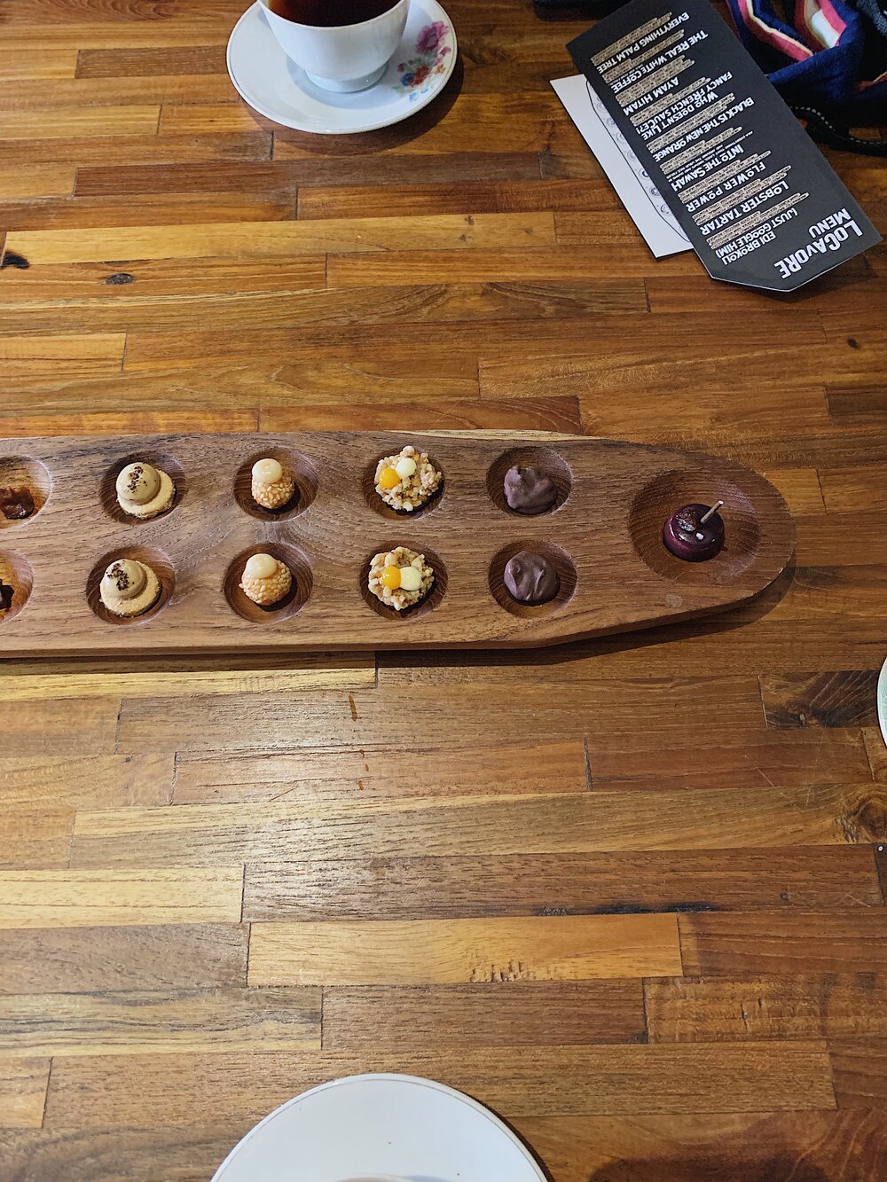  Traditional Indonesian game board of Congklak filled with sweet chocolates, ganaches, and other sweet treats 