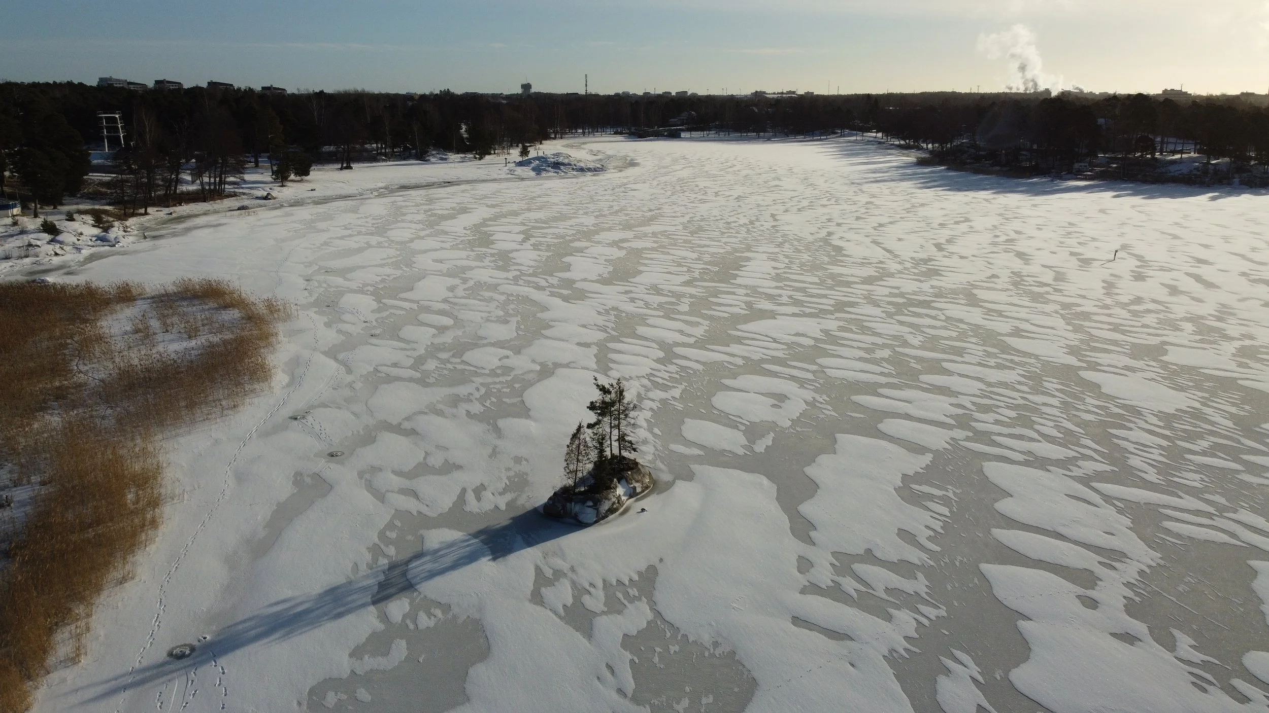 A floating concrete island planted with pines, juniper, hemlock and coastal plants, part of a site-specific environmental artwork by Raimo Saarinen in Otanlahti, Rauma.