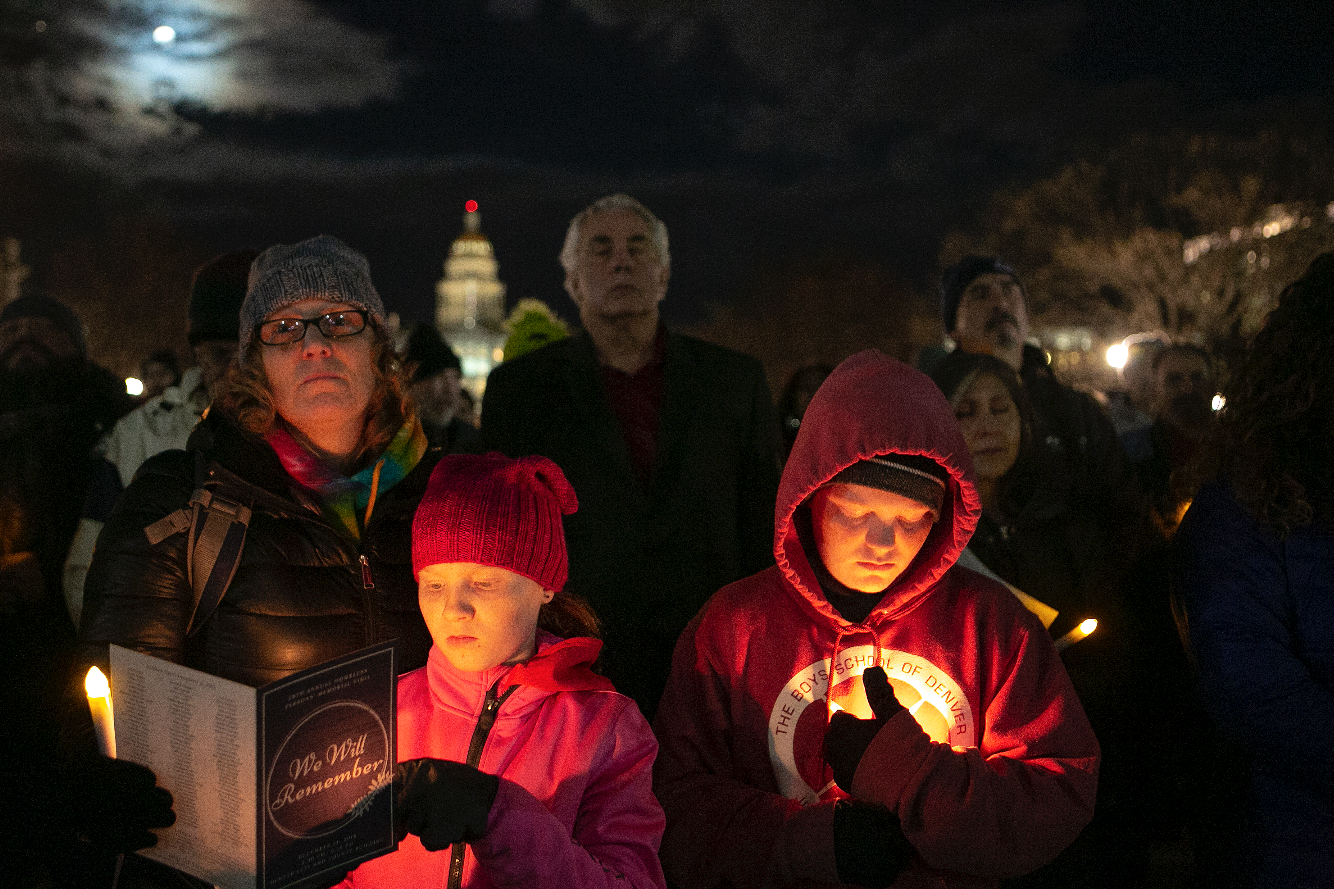 Missy Mishflanagan stands with her children, Sean and Mimi, during the vigil. Mishflanagan works with homeless veterans at the Department of Veteran’s Affairs.