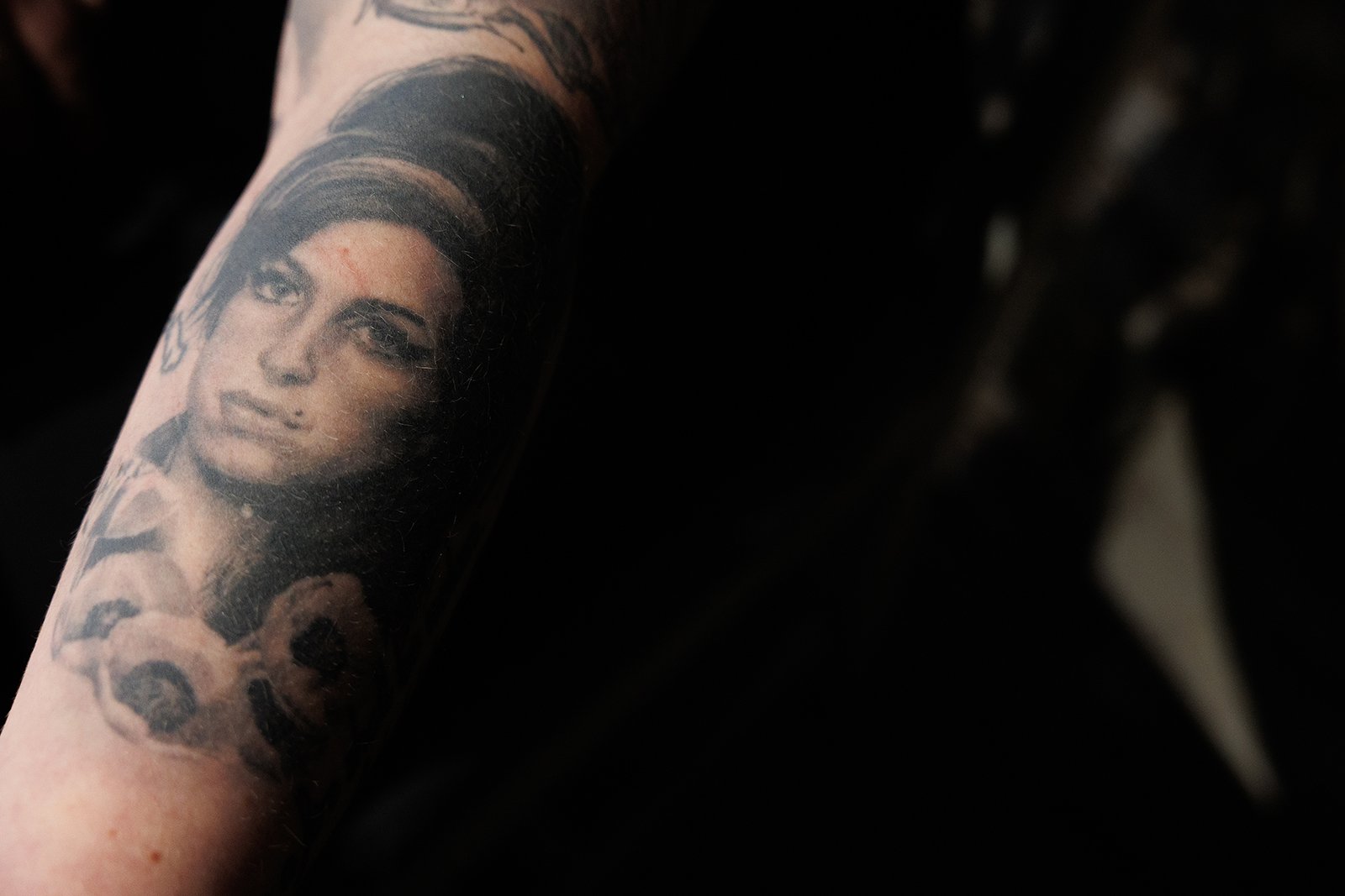  Sally Gibbens shows her tattoo of singer Amy Winehouse, who died of “alcohol toxicity.” Credit: GILES CLASEN 