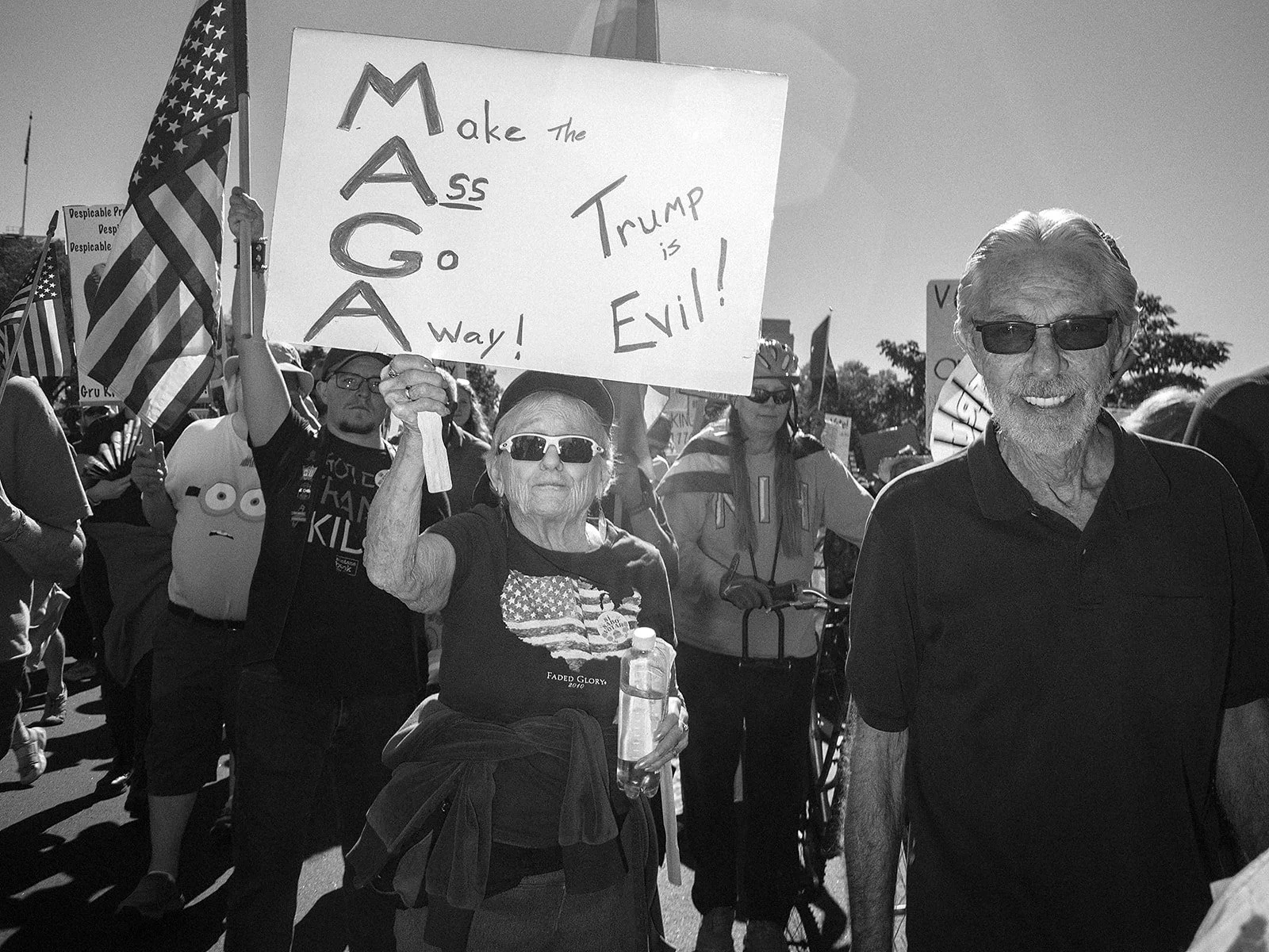 Members of the crowd carry signs expressing opposition to President Donald Trump during the No Kings demonstration in Denver on Saturday, Oct. 17, 2026. Photo by Jeff Tidwell for the Denver Voice.