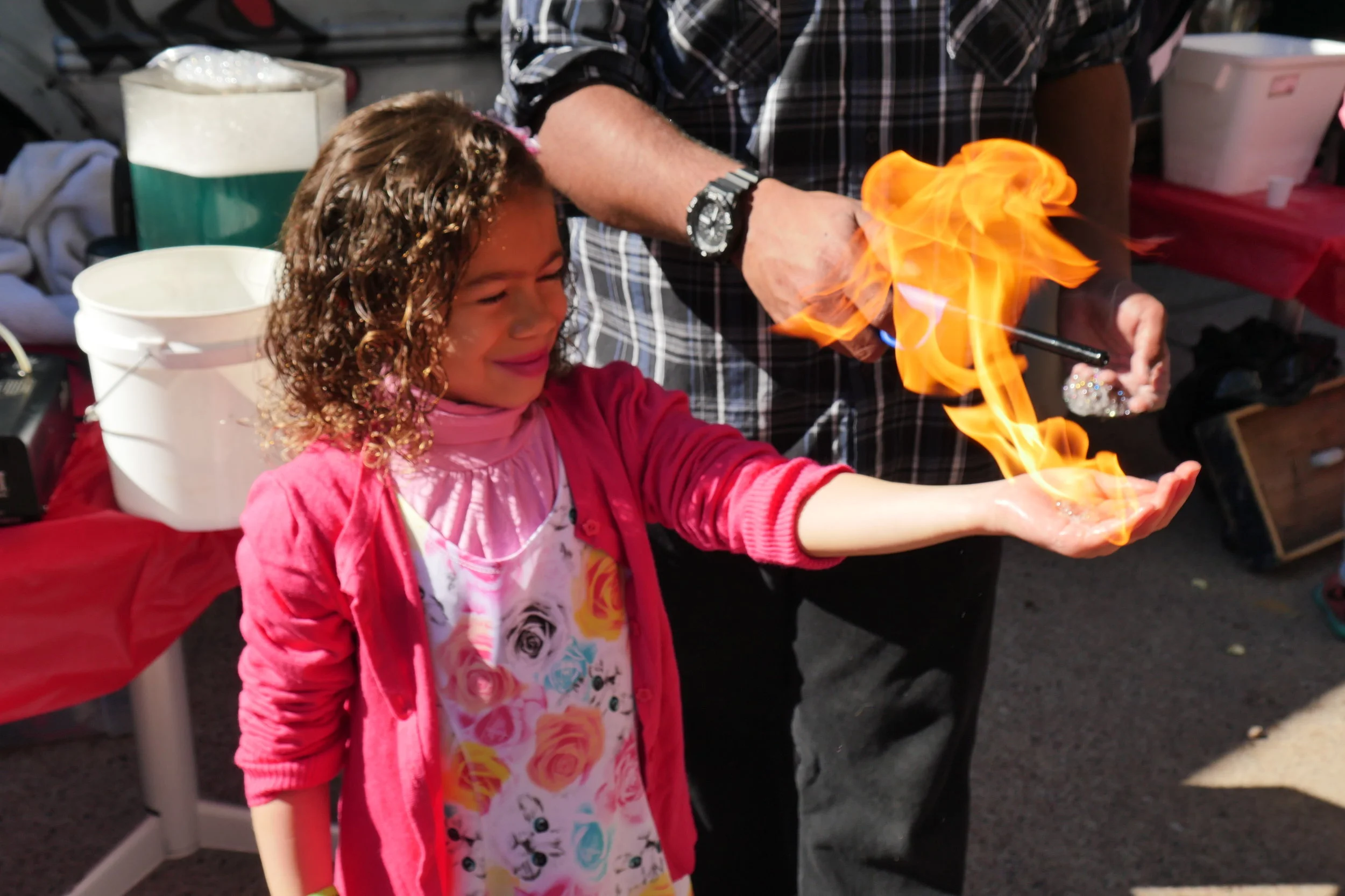 Brisa Mady, 6, briefly holds fire until it dissipates into the air during an outdoor physics demonstration. (Nicholas Serpa/DD)