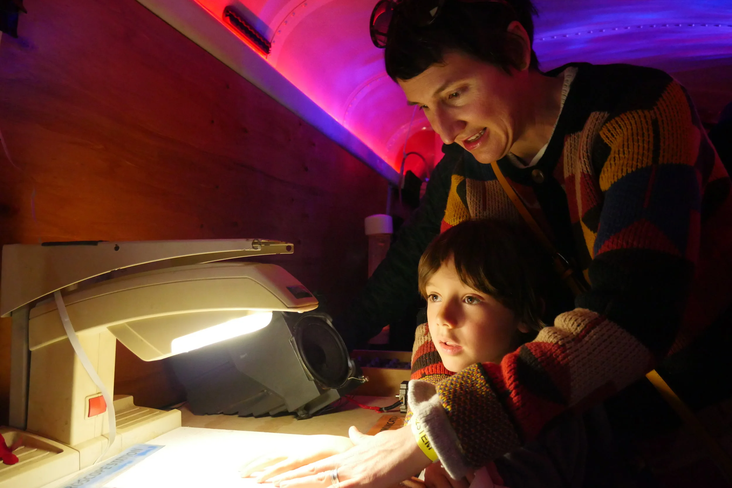 Carrie Wheeler and her son Wilson Wiggins, 5, examine their hands under a microscope inside the Physics Bus exhibit. (Nicholas Serpa/DD)