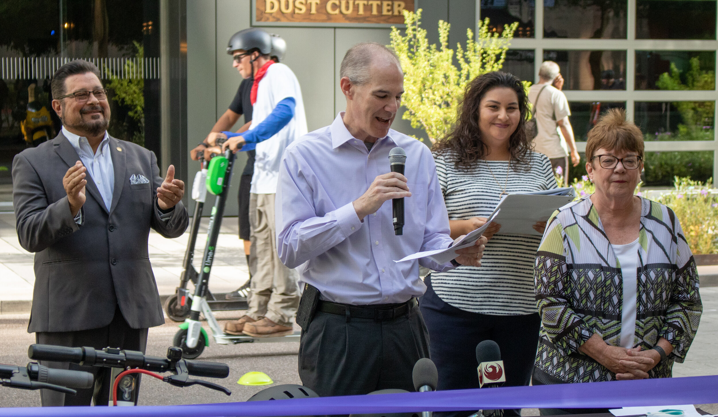  Jon Brodsky, executive director of Phoenix Community Alliance (center), discusses Phoenix's new e-scooter pilot program alongside Phoenix councilman Michael Nowakowski (left), City of Phoenix assistant street transportation director Briiana Velez (c