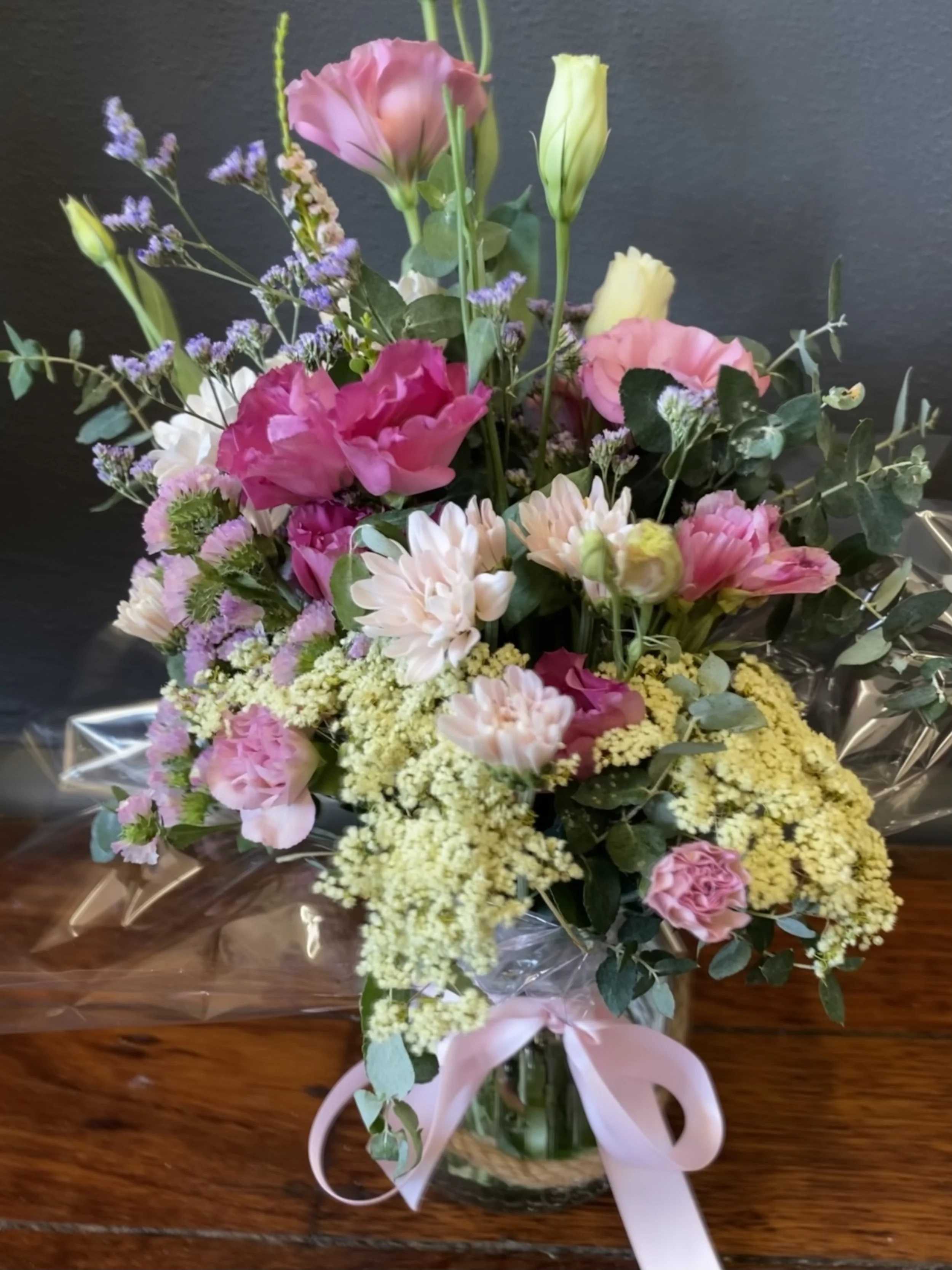 seasonal fresh flowers in bright or pastel colours in a hurricane glass vase