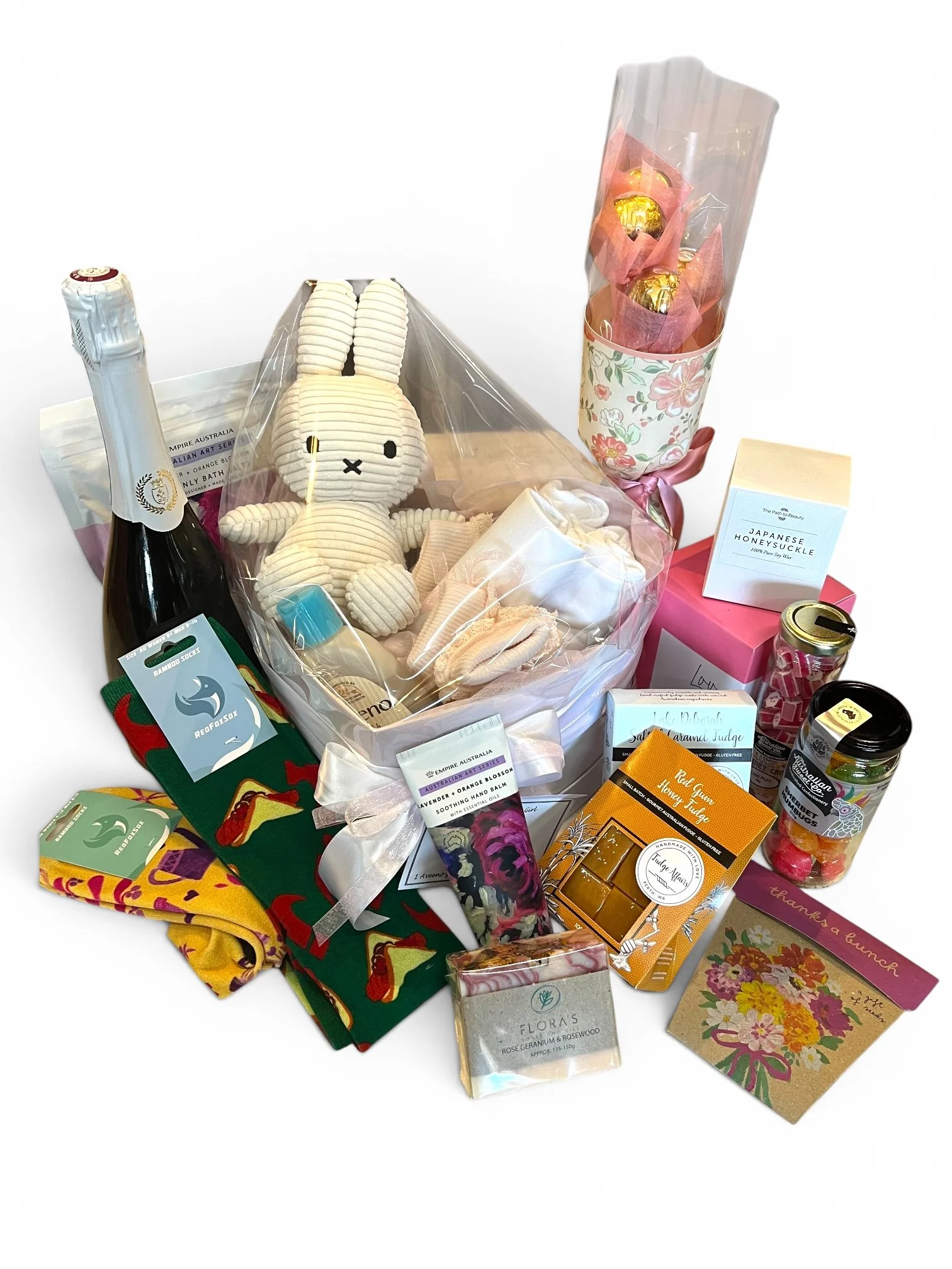 A variety of gift items including a plush bunny, chocolates, skincare products, and decorative packaging on a white background available at Lilypilly Perth