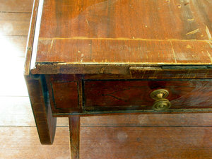 Extensive water damage to an English sofa table due to a major water leak