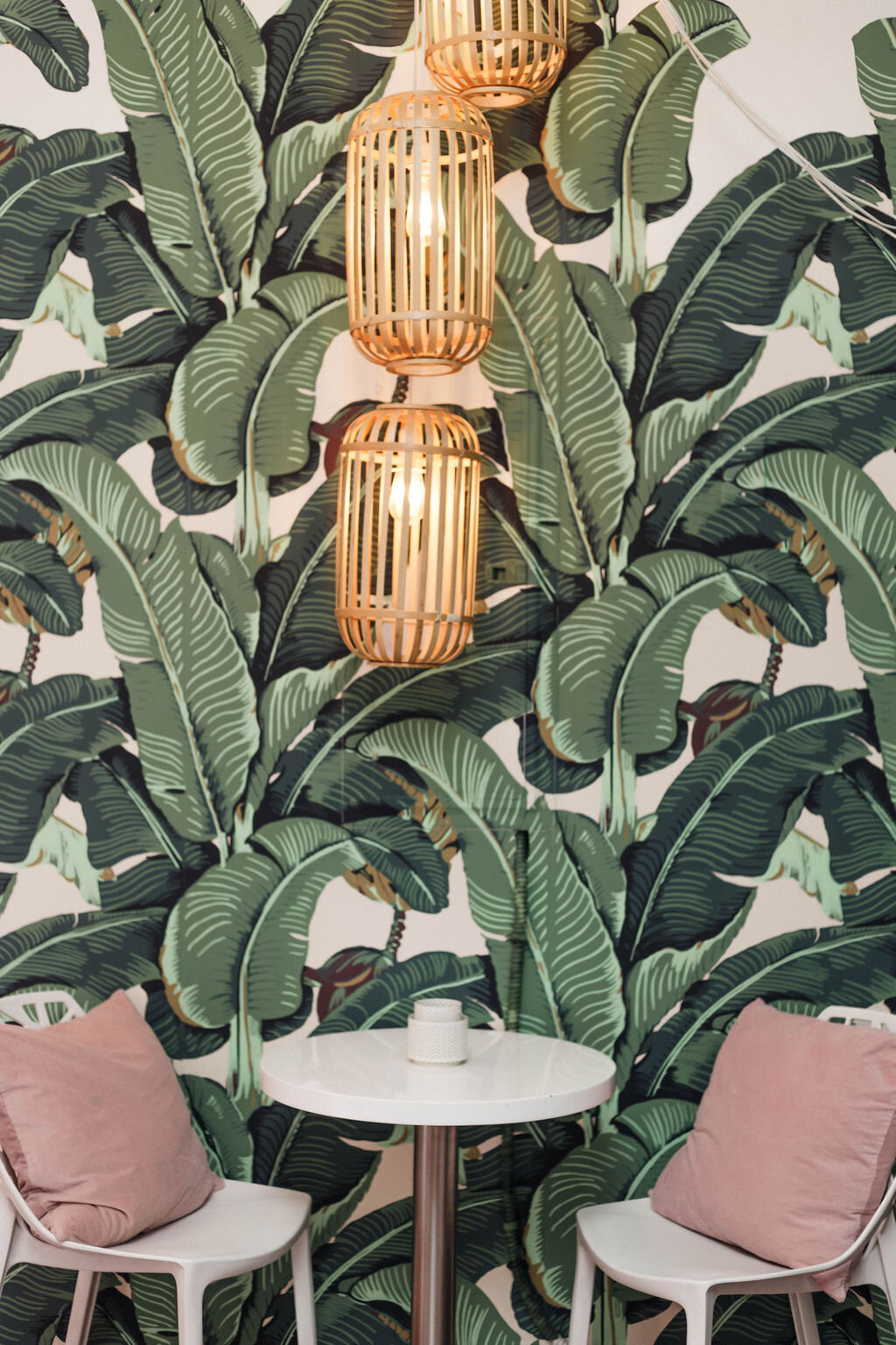 banana leaf wallpaper, pink phone &amp; small seating area