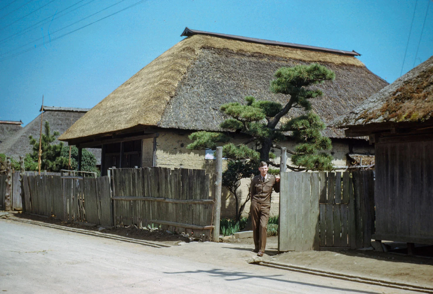 204- George Butler in front of village house