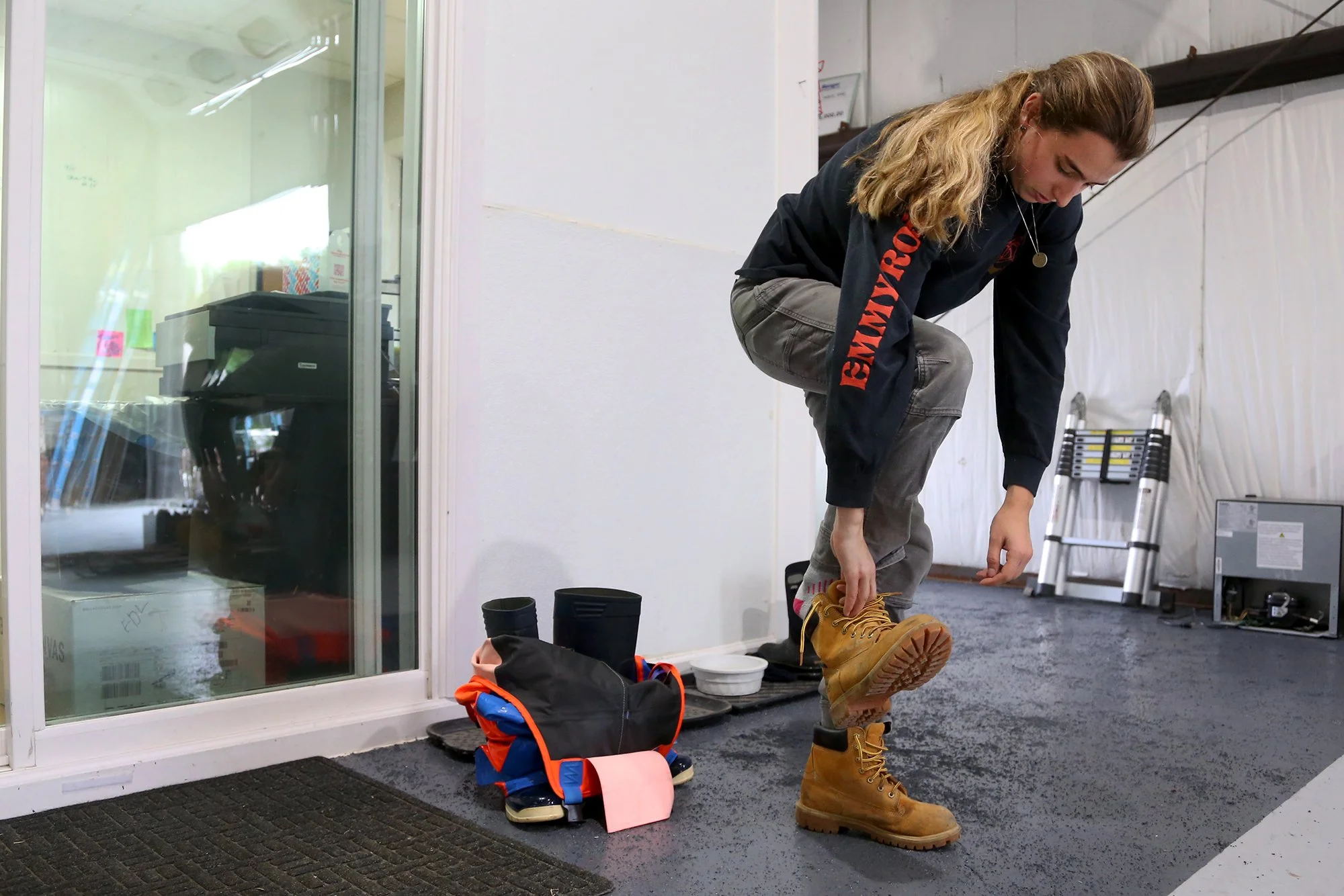 Jillian Robillard changes out of her rubber boots and waders after processing shellfish at Jillian’s facility in Kittery on September 17, 2021.