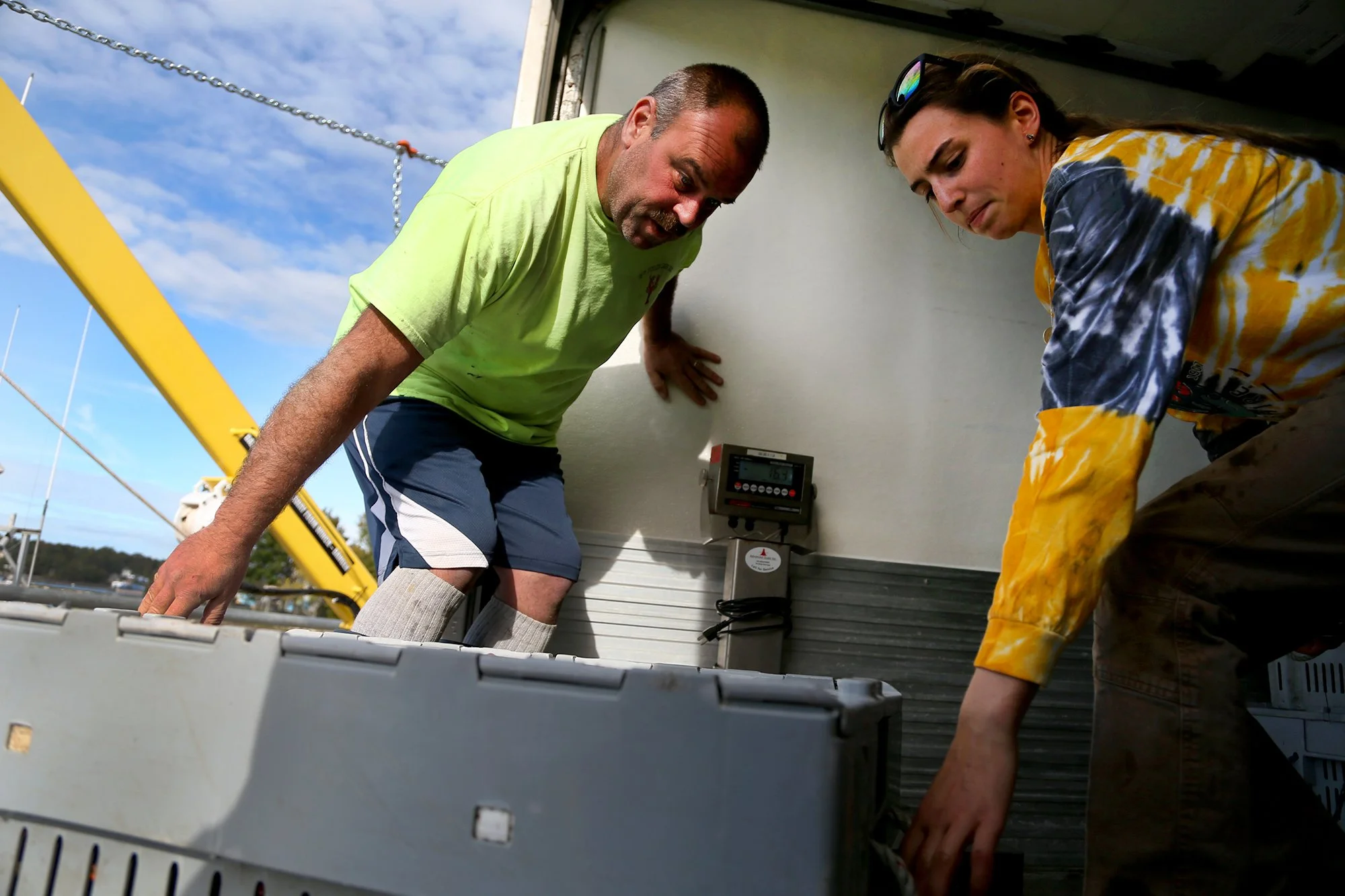 From left, Dennis Robillard helps his daughter, Jillian, bring crates into her truck at the docks in Portsmouth on October 5, 2021.