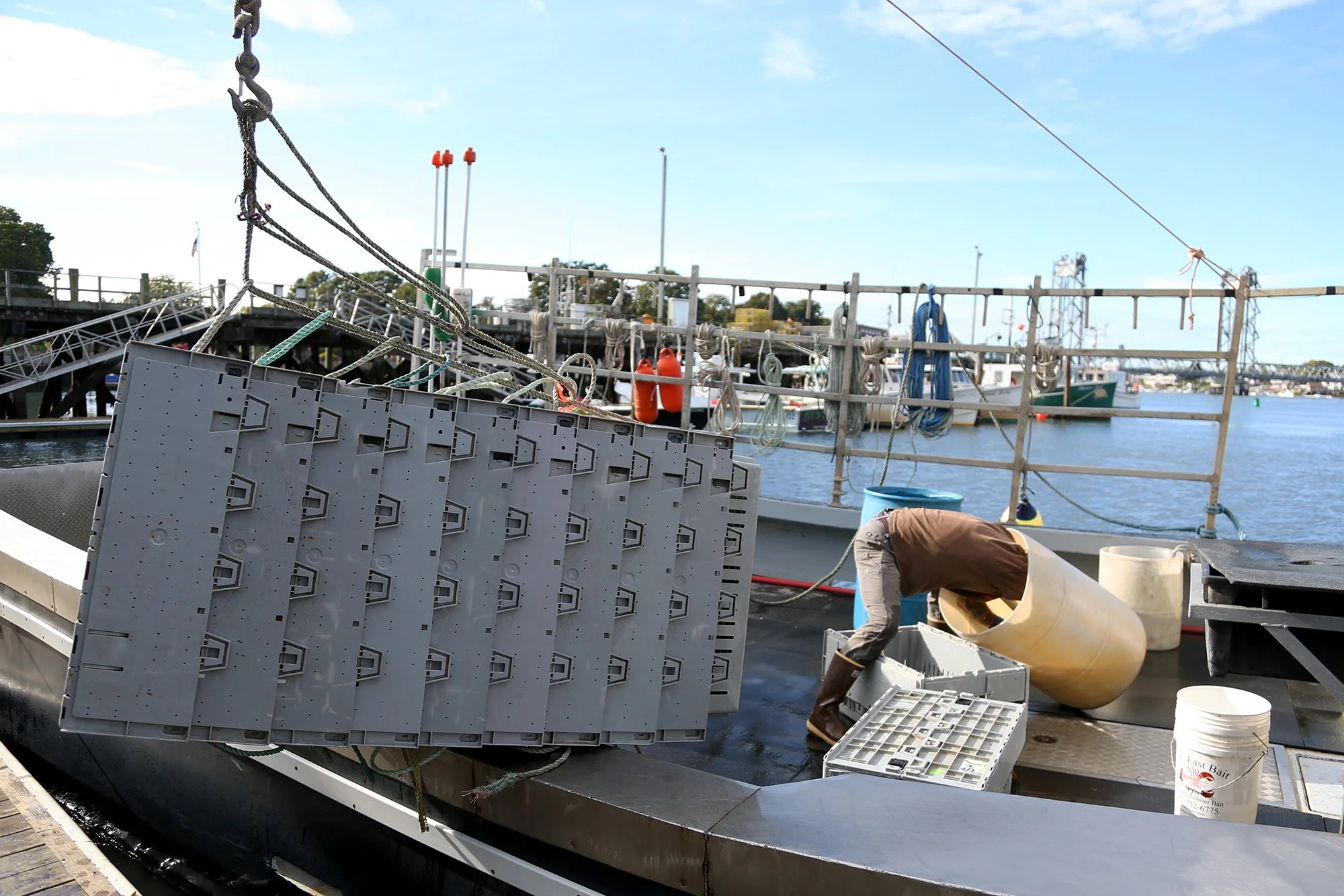 Deck hands help loads up crates of lobsters and crabs at the docks in Portsmouth on October 5, 2021.