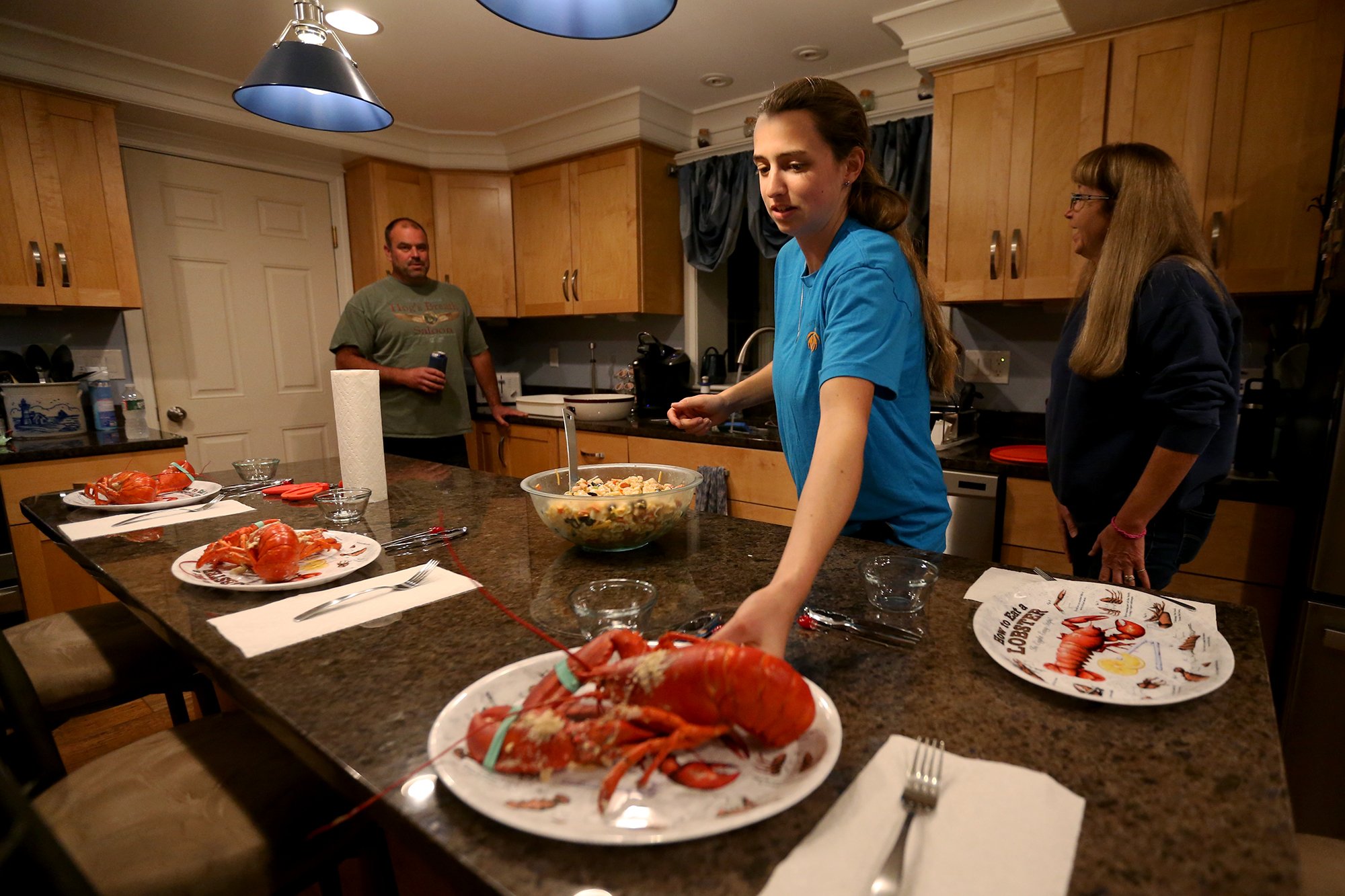 From left, Dennis, Jillian and Julie Robillard cook lobsters and crabs for dinner at their Kittery home on October 22, 2021.