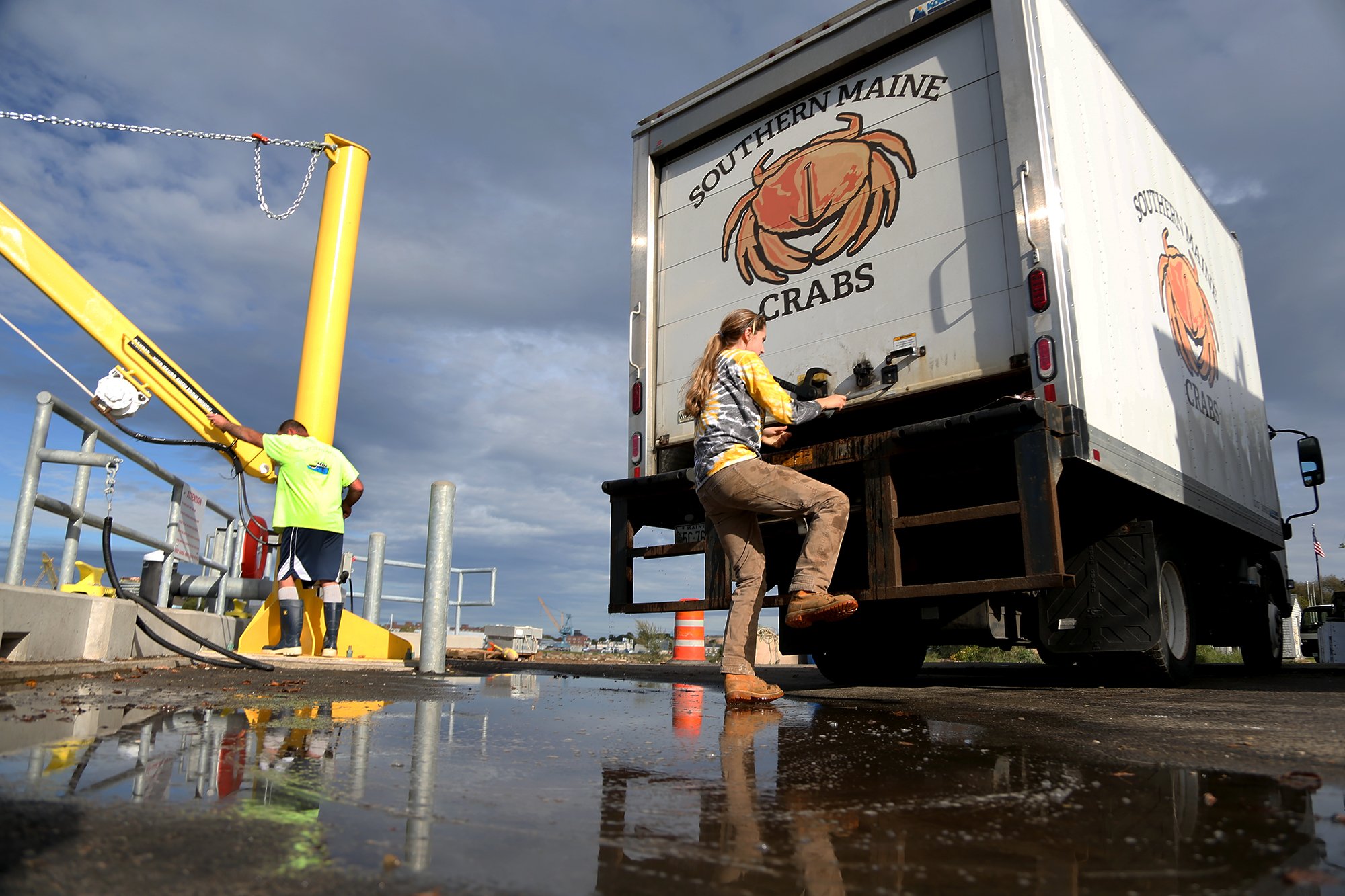 From left, Dennis Robillard adjusts the crate crane as his daughter, Jillian, closes up her truck at the docks in Portsmouth on October 5, 2021.