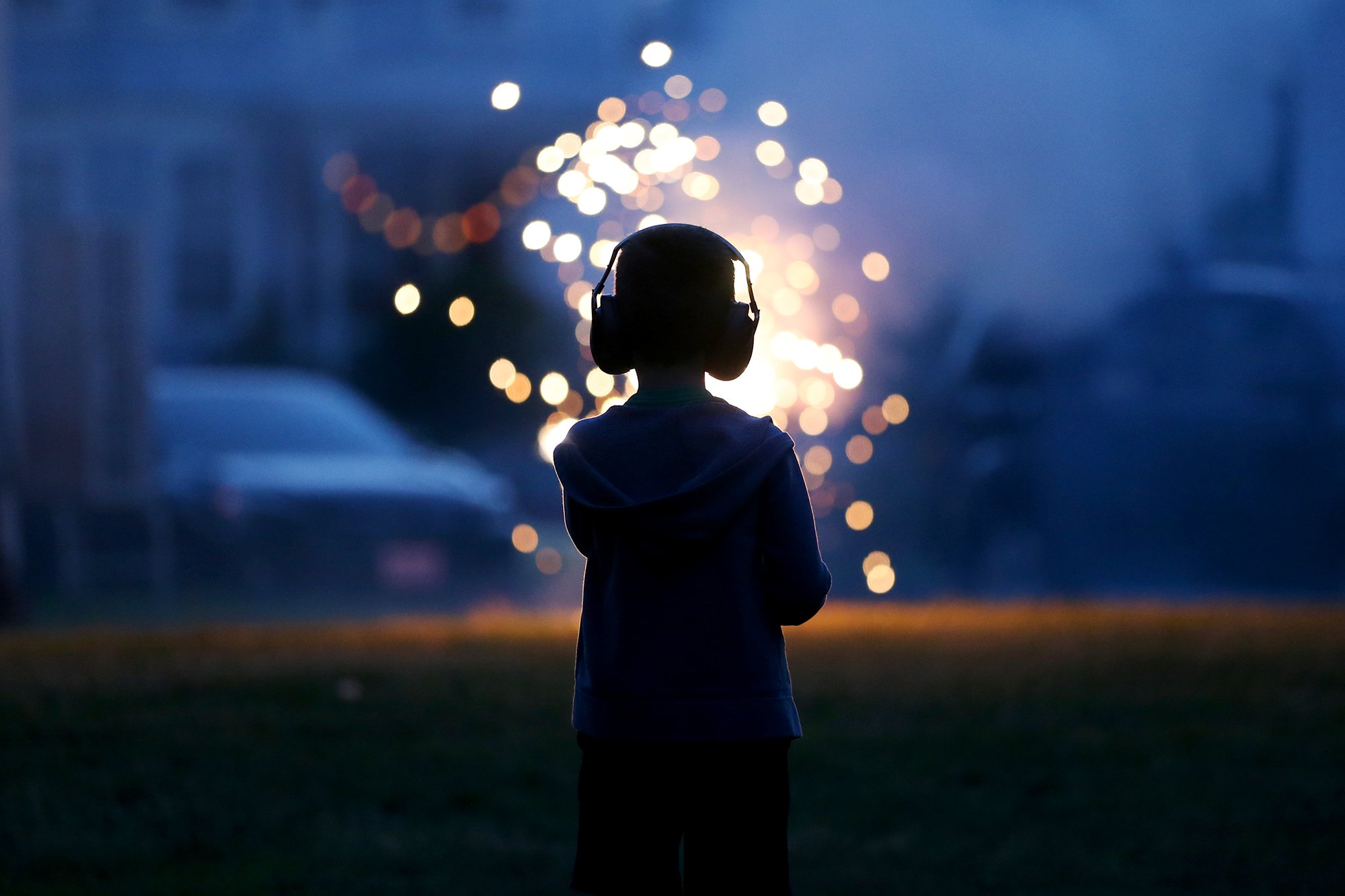 A boy enjoys fireworks in a backyard before the 4th of July fireworks celebration in Portsmouth on July 5, 2021.