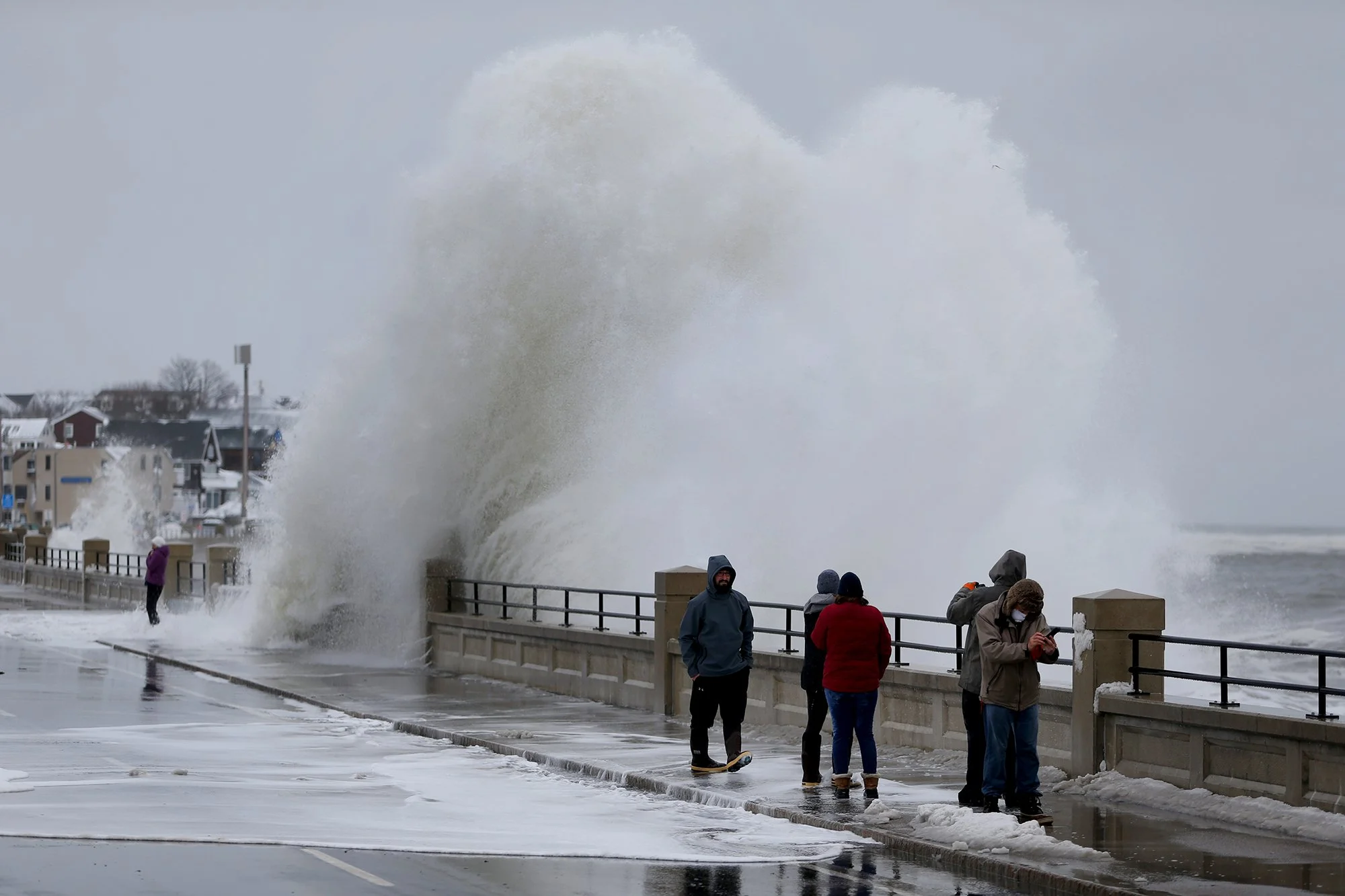 Locals get splashed by waves at high tide on Ocean Boulevard in Hampton Beach on Feb. 2, 2021.