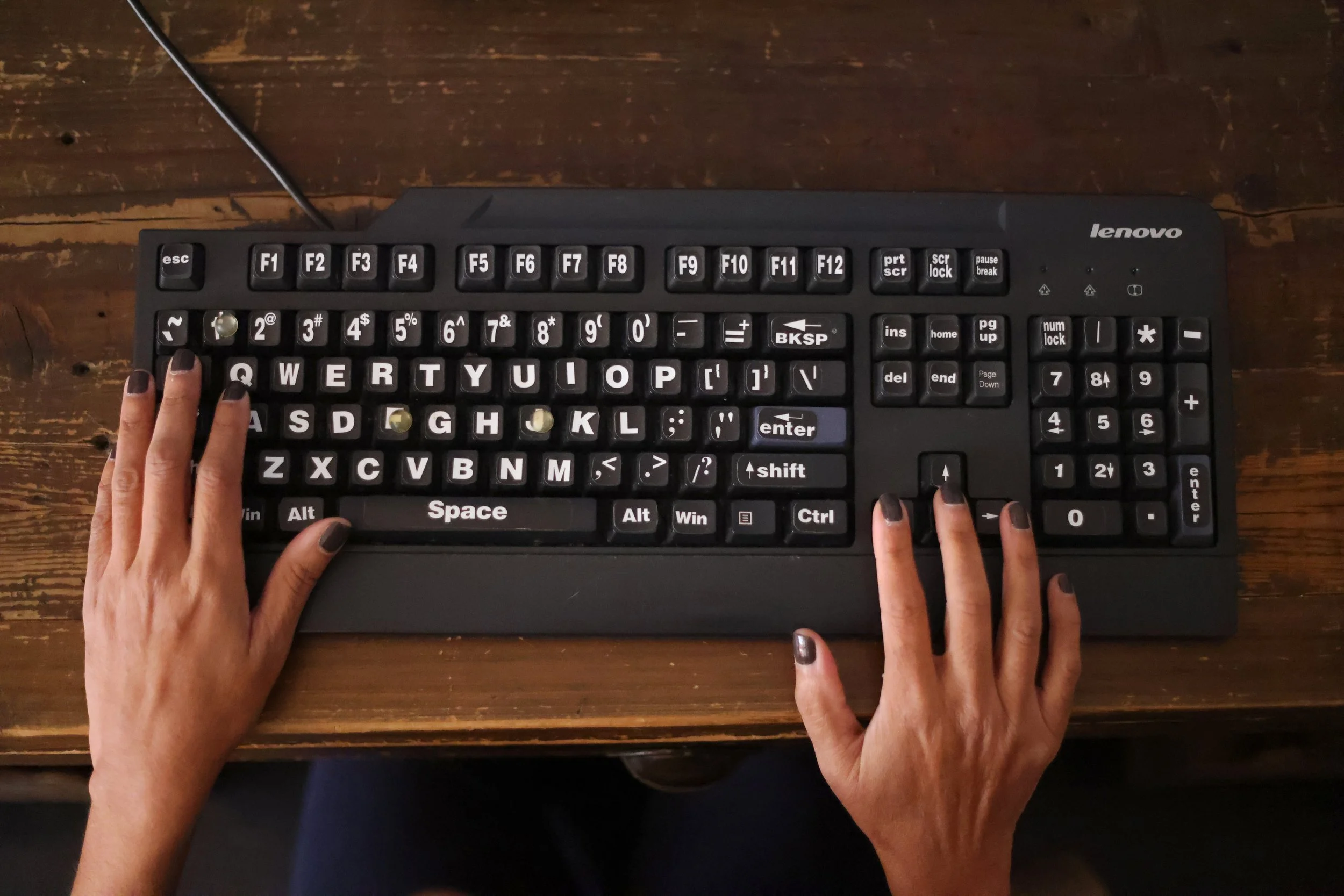 Nisha Falcigno attaches raised buttons and enlarged stickers on her keyboard in addition to being trained in read aloud assistance programs to easily operate her computer.  