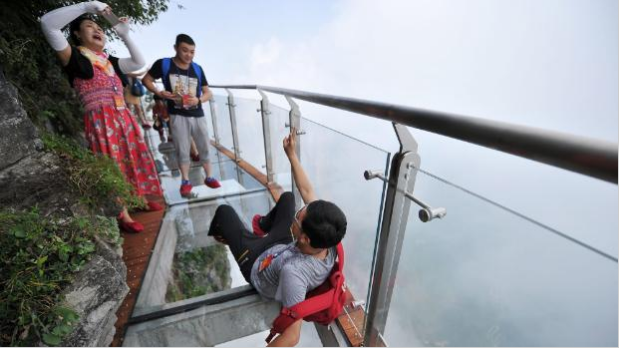 Tourists on China’s “Coiling Dragon Skywalk” – a glass-bottomed path winding around a 300m cliff. If this photo doesn’t make you feel weird, you’re not as acrophobic as the writer of this article.