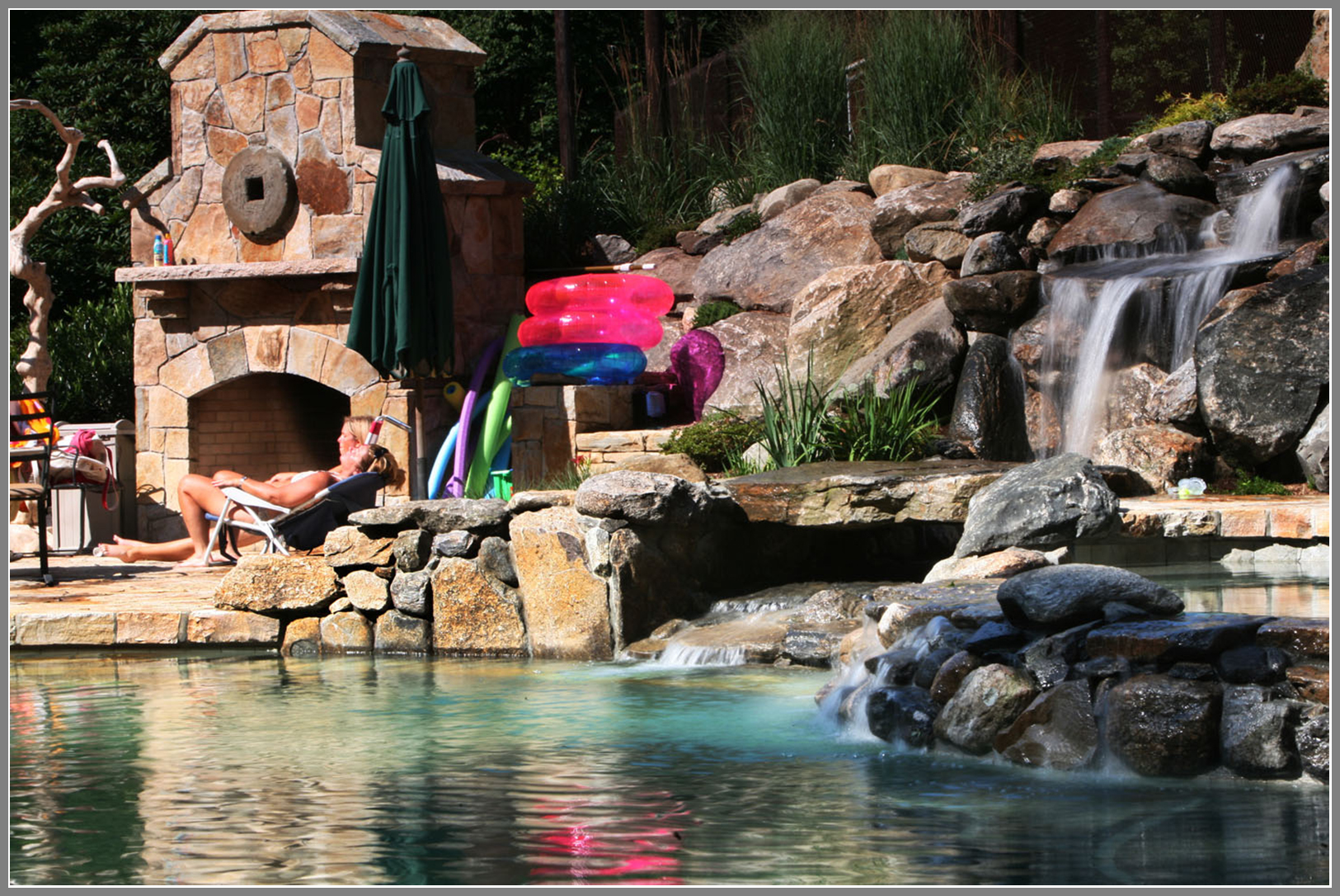 Outdoor fireplace and waterfalls by the pool