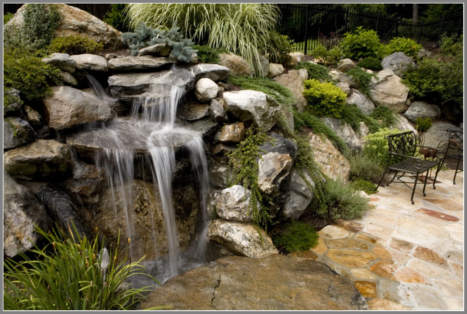Naturalistic waterfall and bridge with boulders