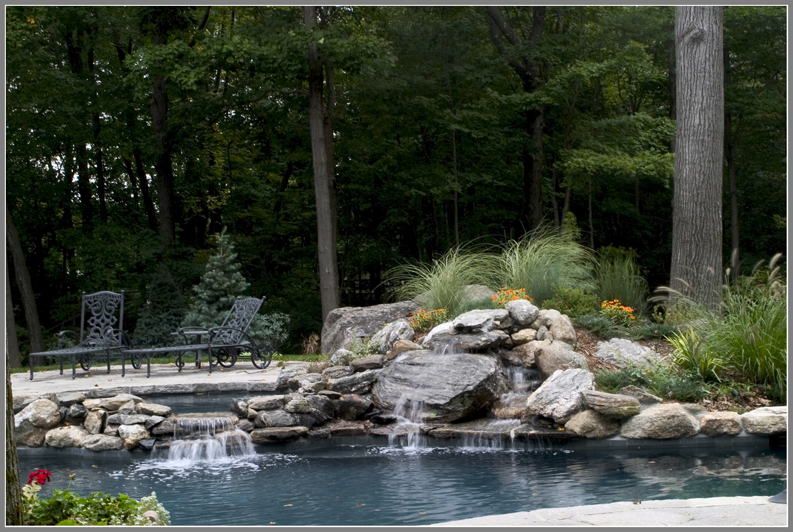 Pool with waterfalls and natural stone spa wall. 