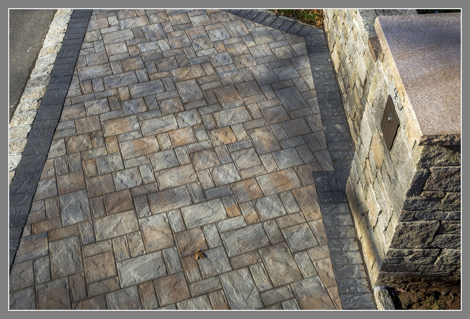  Stone columns, paver driveway with border and cobble stone curb.  