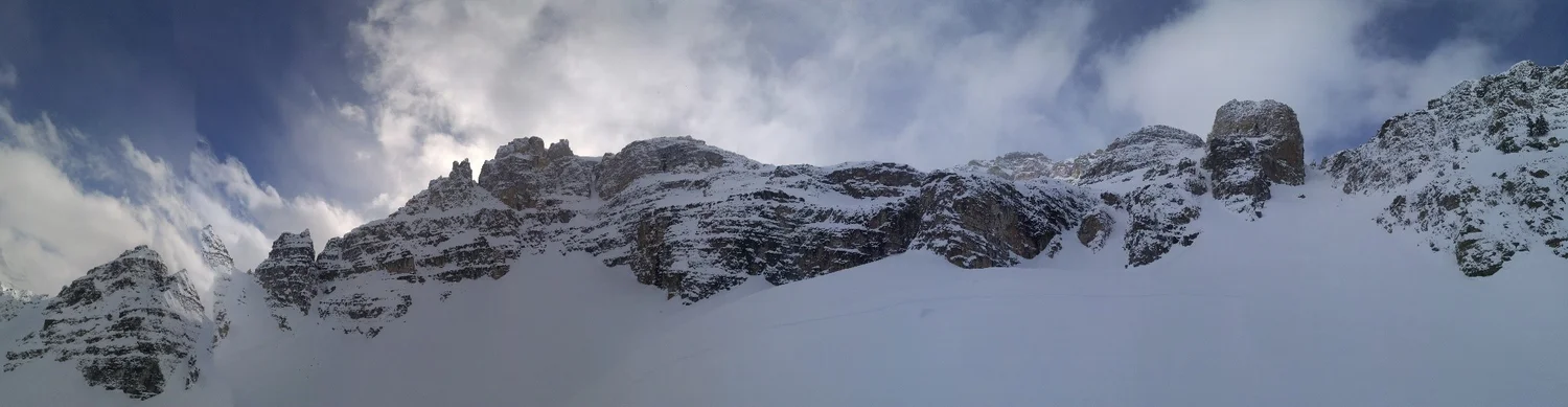 Panorama shot from the basin below Vanguard Peak/South Couloir. South couloir is on the right side of picture. From above, the more tempting descent would take you above the cliffs just lookers left of the South Couloir. At the very least it would mean mandatory air into a tight shoot, or a short rappel. Worst case scenario could involve cliffing out on some very large ledges. This panorama picture also explains why bootpacking up the south couloir is the only way out of the basin and is recommended in Summits and Icefields. If you are also in a position of looking for the couloir without having boot packed up it, make sure you get it right.