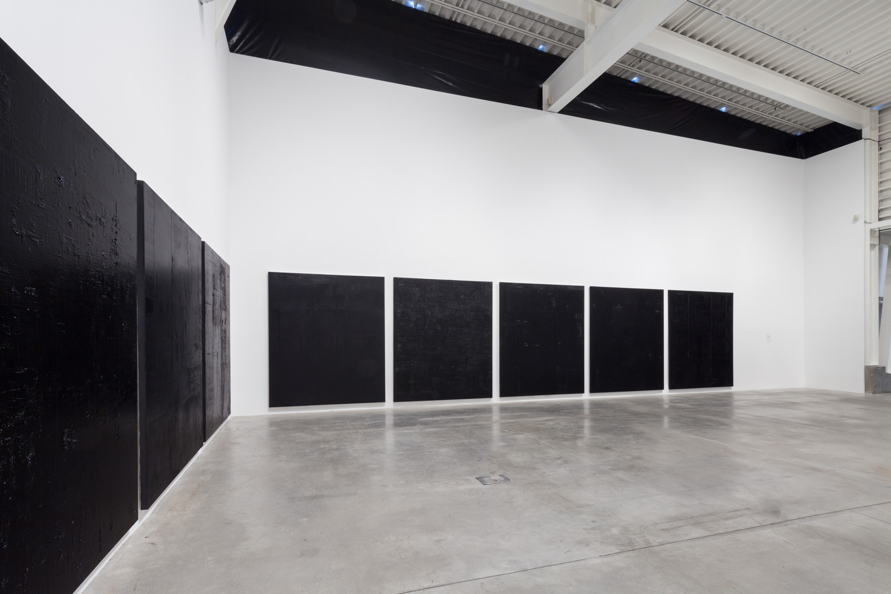  Untitled black monochrome paintings (3.-10.PBk9.CI77267/PBk11.Fe3O4) The Frequency 10 series. Oil, grit, graphite on canvas, each 213.36cm x 182.88cm (84 inches x 72 inches). Image courtesy Morris and Helen Belkin Art Gallery.    