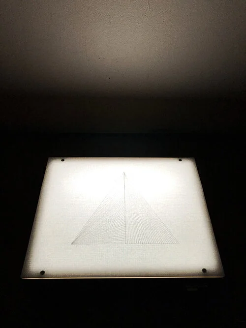 Pyramid floating on the horizon line of humanity. Graphite on bond paper placed on light box, drawing 9 ¾ x 12 ¼ overall 9 ¾ x 12 ¼ x 3 ¼” , 2019.
