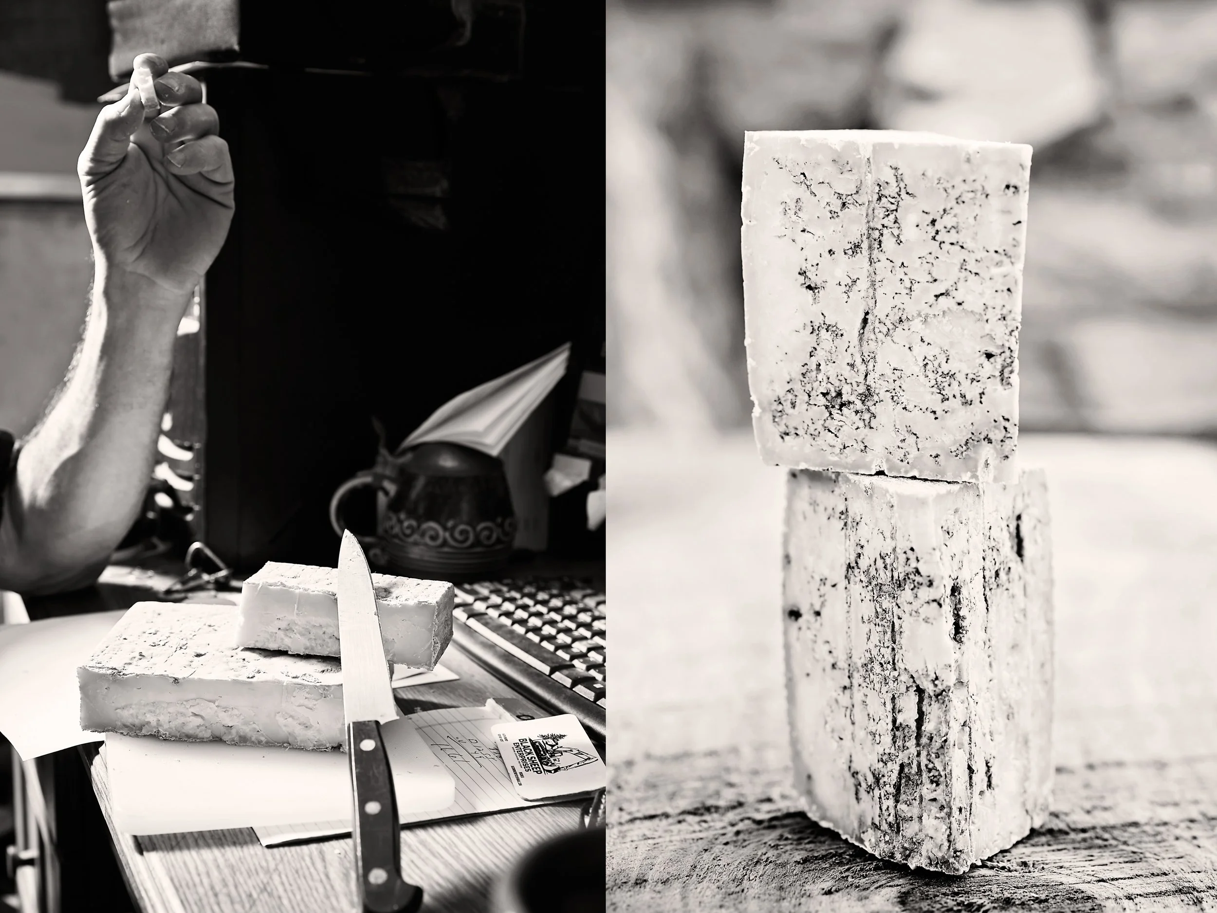A man's hand holding cheese and cheese on a desk with a knife. Victor Chiarizia having lunch at his computer. A stack of blue cheese from Blue Ridge Mountain Creamery. Photos by Stacey Van Berkel.