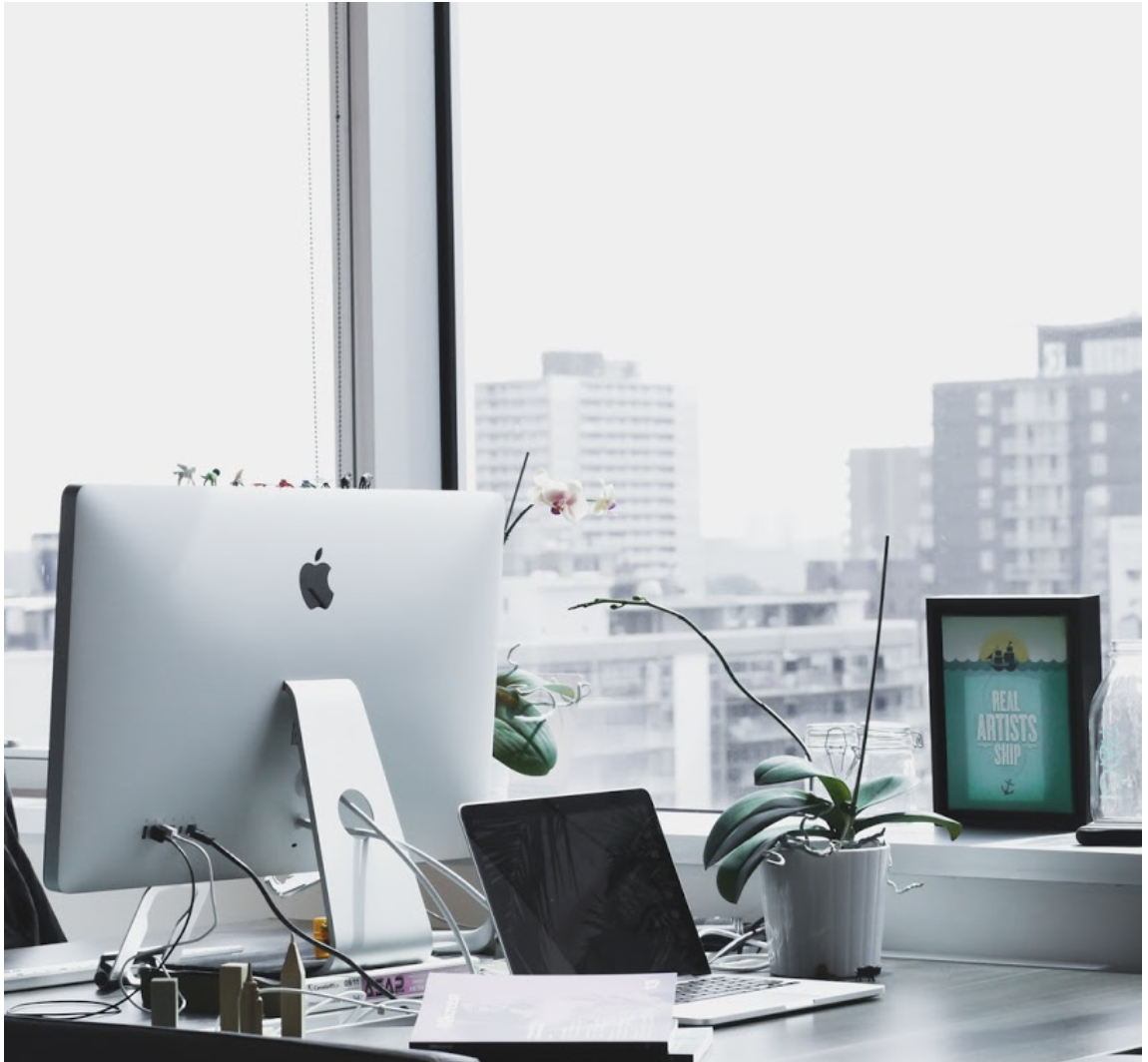 Espace de travail avec ordinateur menant a une vue sur une grande ville