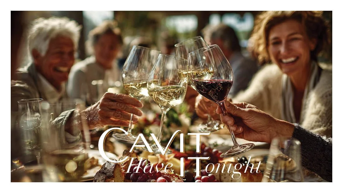 People raising their glasses of wine in a toast at a dinner party.