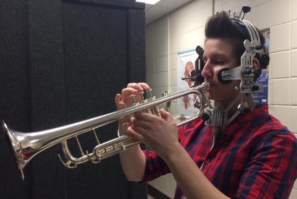 Dr. Youngs playing trumpet with an ultrasound probe attached to stabilization headset.