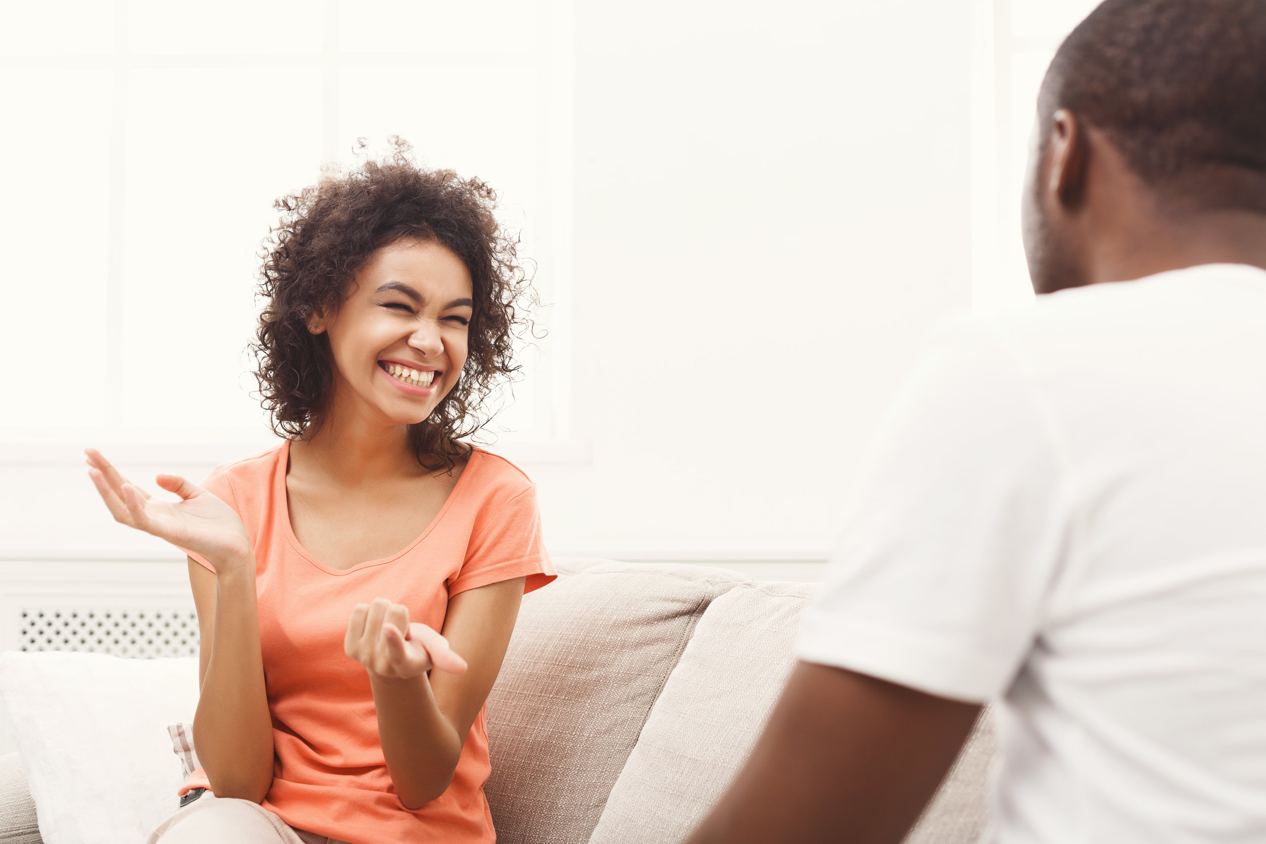 smiling-black-couple-drinking-coffee-on-sofa-at-PH43ENW.jpg