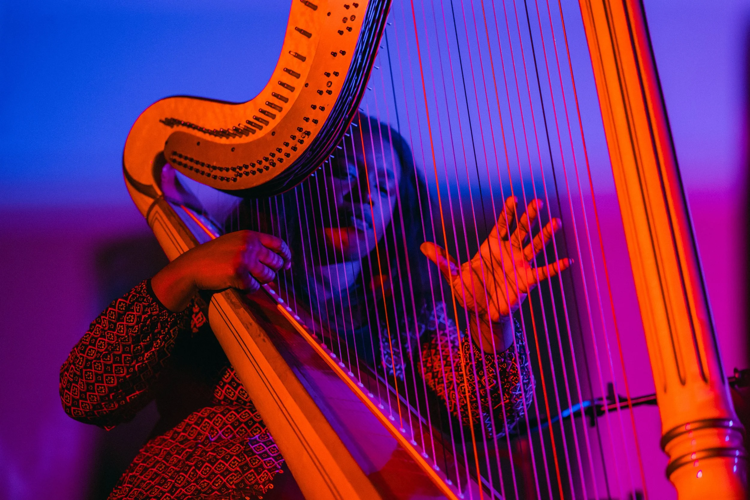 a black African American female harpist in new orleans and new york playing a concert harp instrument on stage in ambient light jazz classical original work cassandra cassie watson francillon
