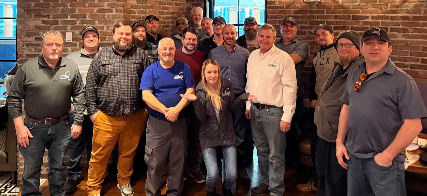 Group image of the 2026 Taylor Upstate team members at a restaurant with a brick wall