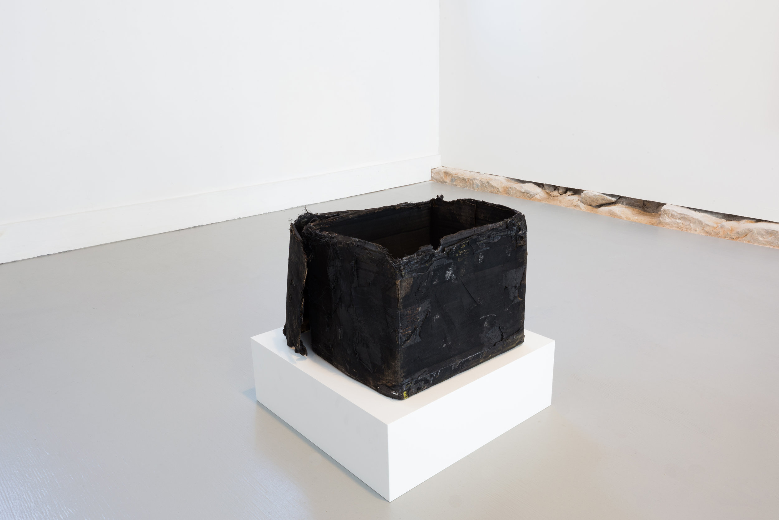 Harold Mendez. "Untitled (Death Mask)," 2015. Burned cardboard box, soot, toner, oxidized copper reproduction of pre-Columbian death mask from the Museo del Oro (Bogota, Colombia). 14" x 20" x 14"